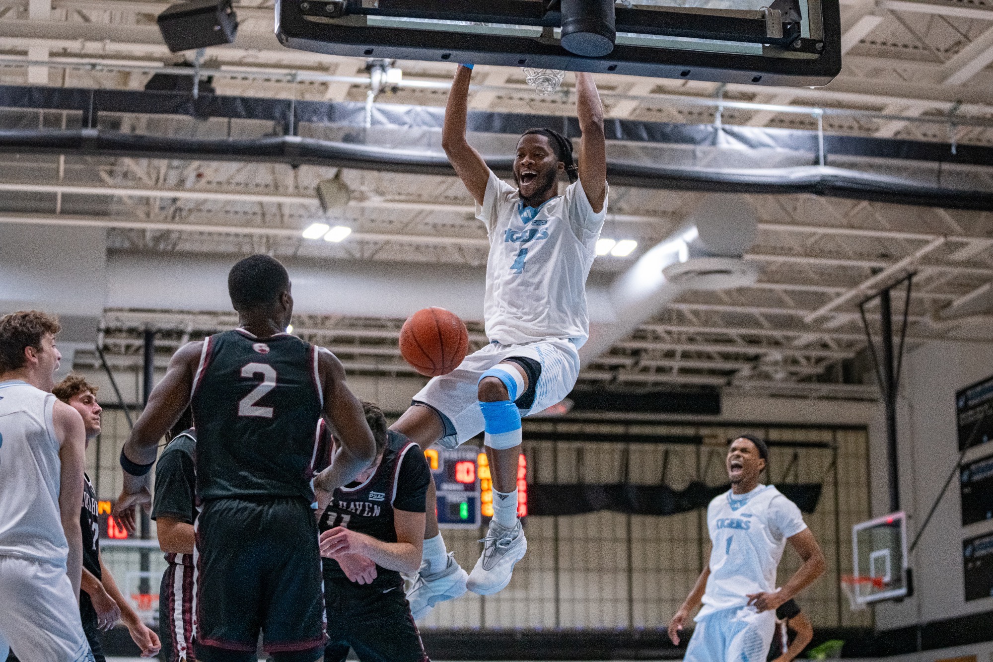 Karrington Wallace holding on to the rim after dunking