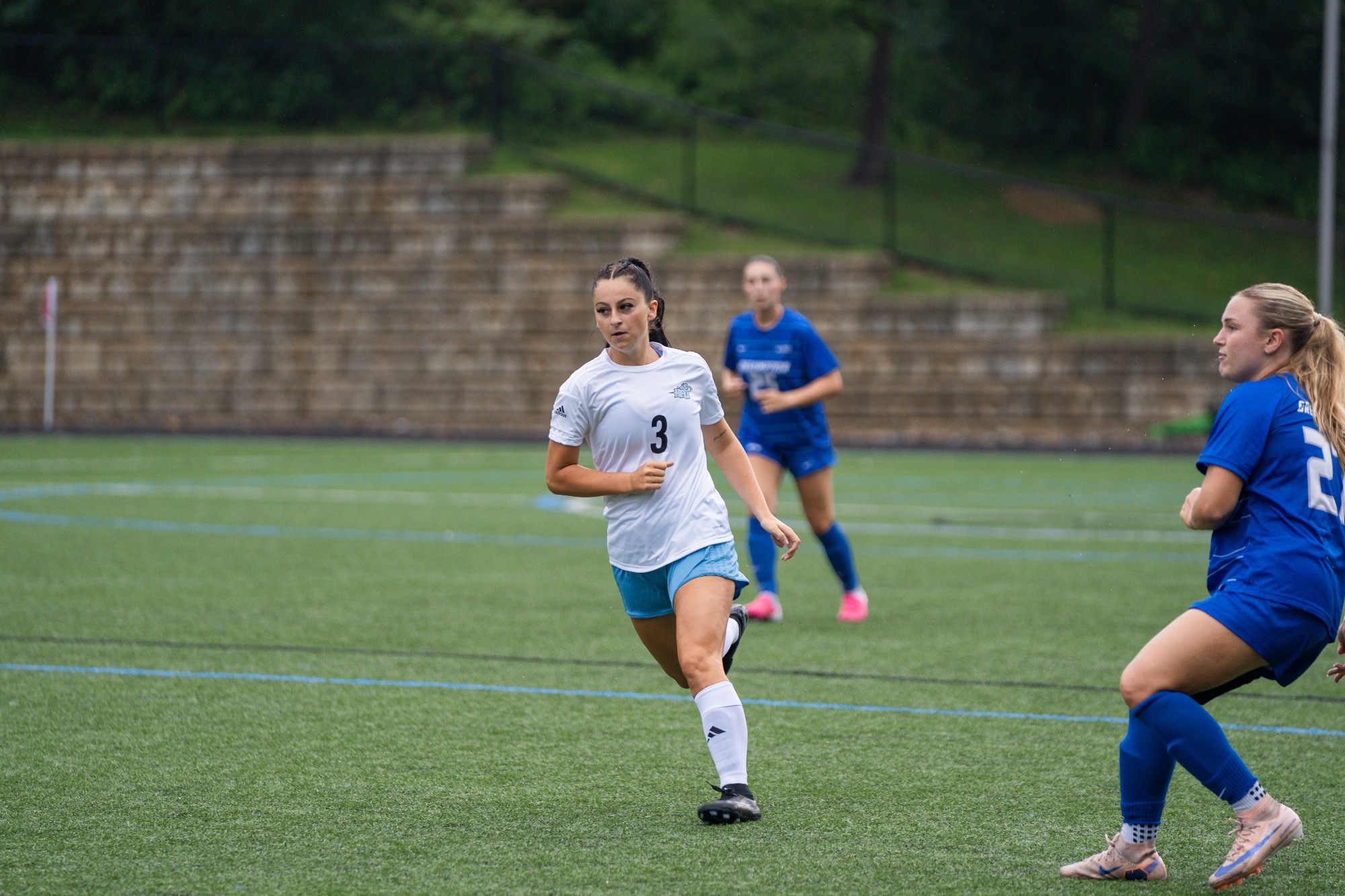 Gianna Georgette jogging on the field, a defender to her left