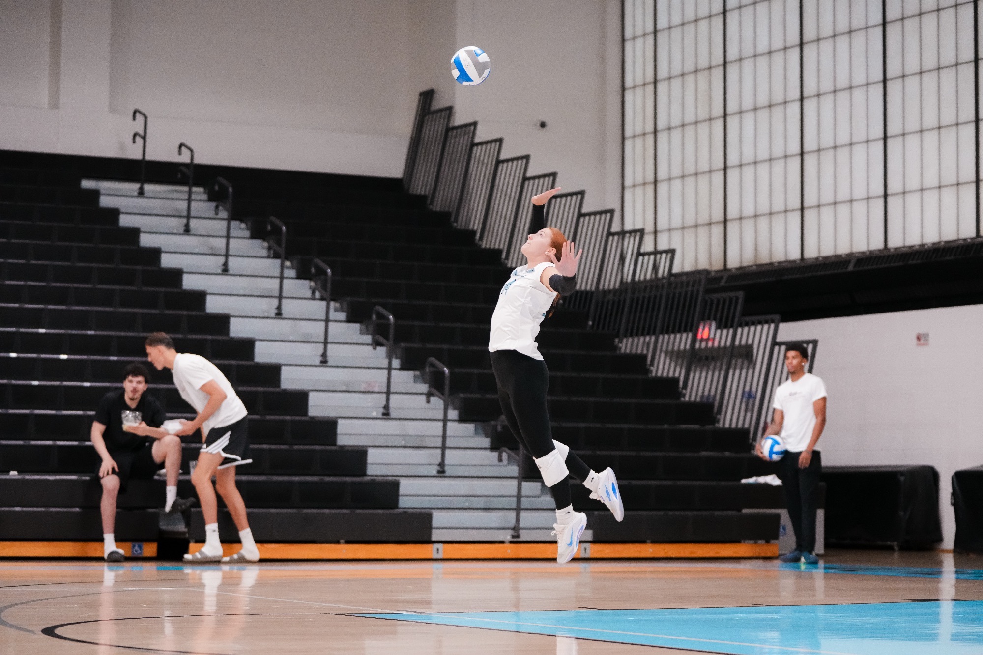 Rosslyn Briggs in the air, about to make contact with the ball on a serve