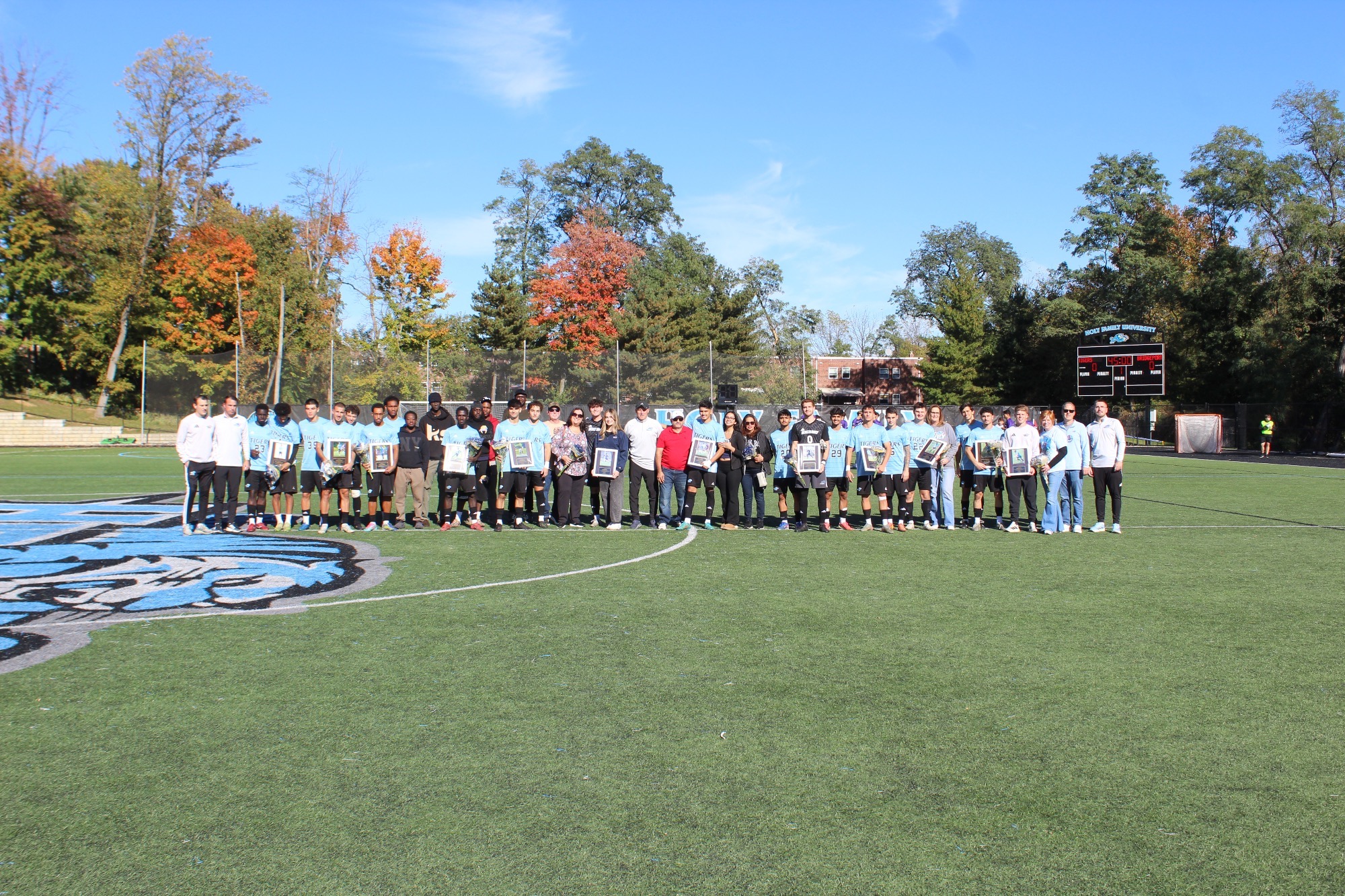 The 2026 HFU Men's Soccer Team takes a group picture on the field, with familles, friends and coaches