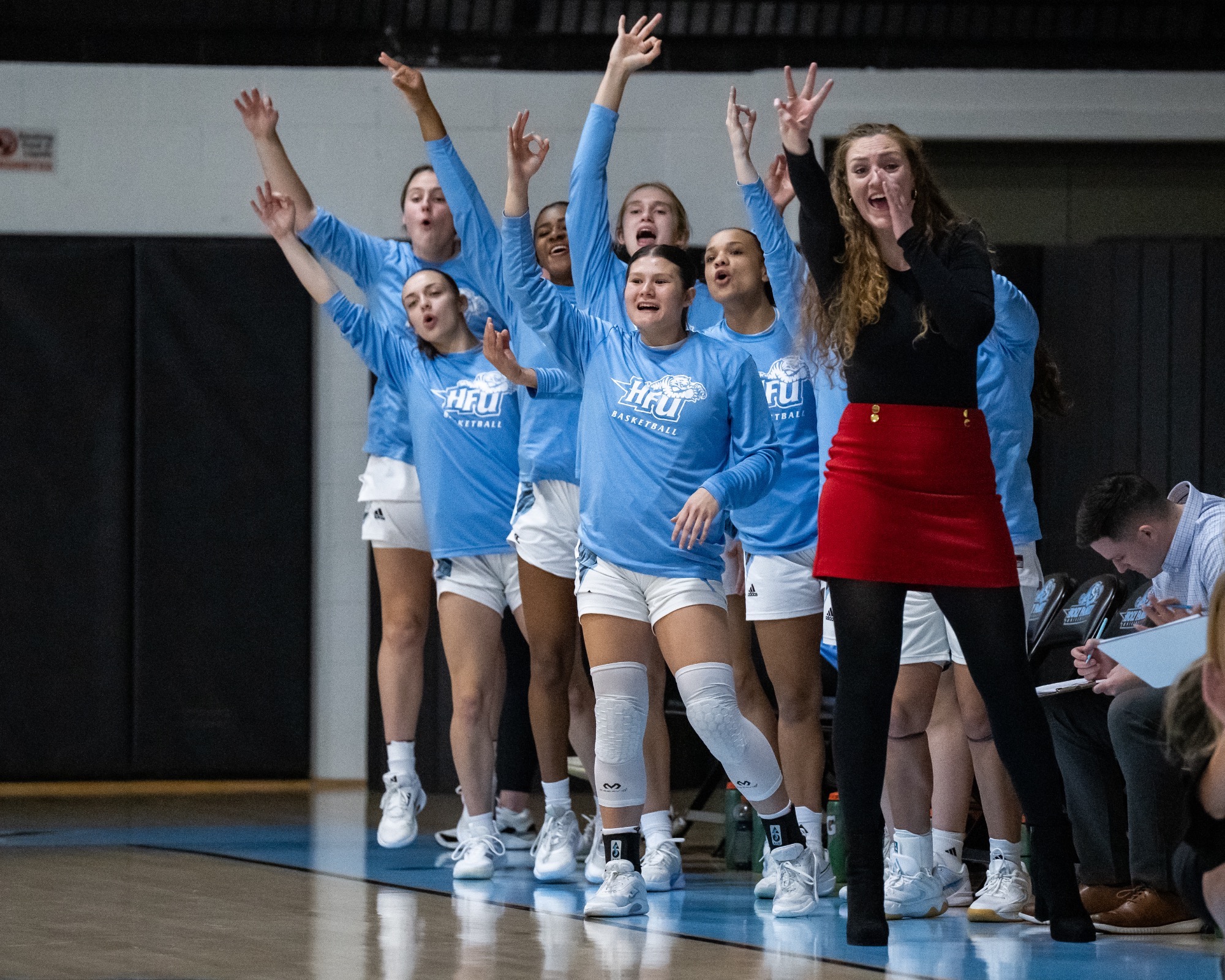 The HFU Women's Basketball bench celebrates following a 3-pointer