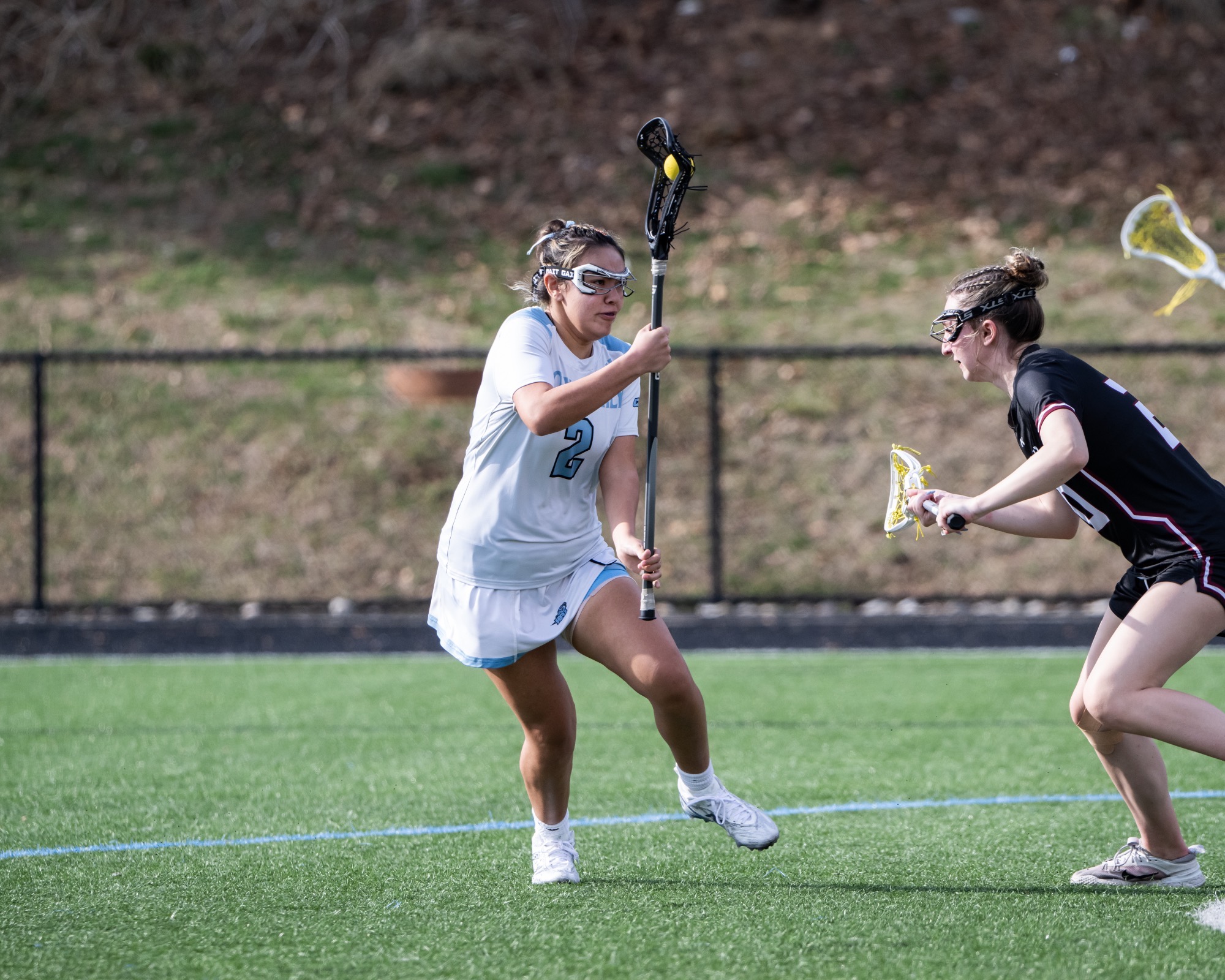 Julie Gallardo cardles her stick with the ball in it in front of a defender