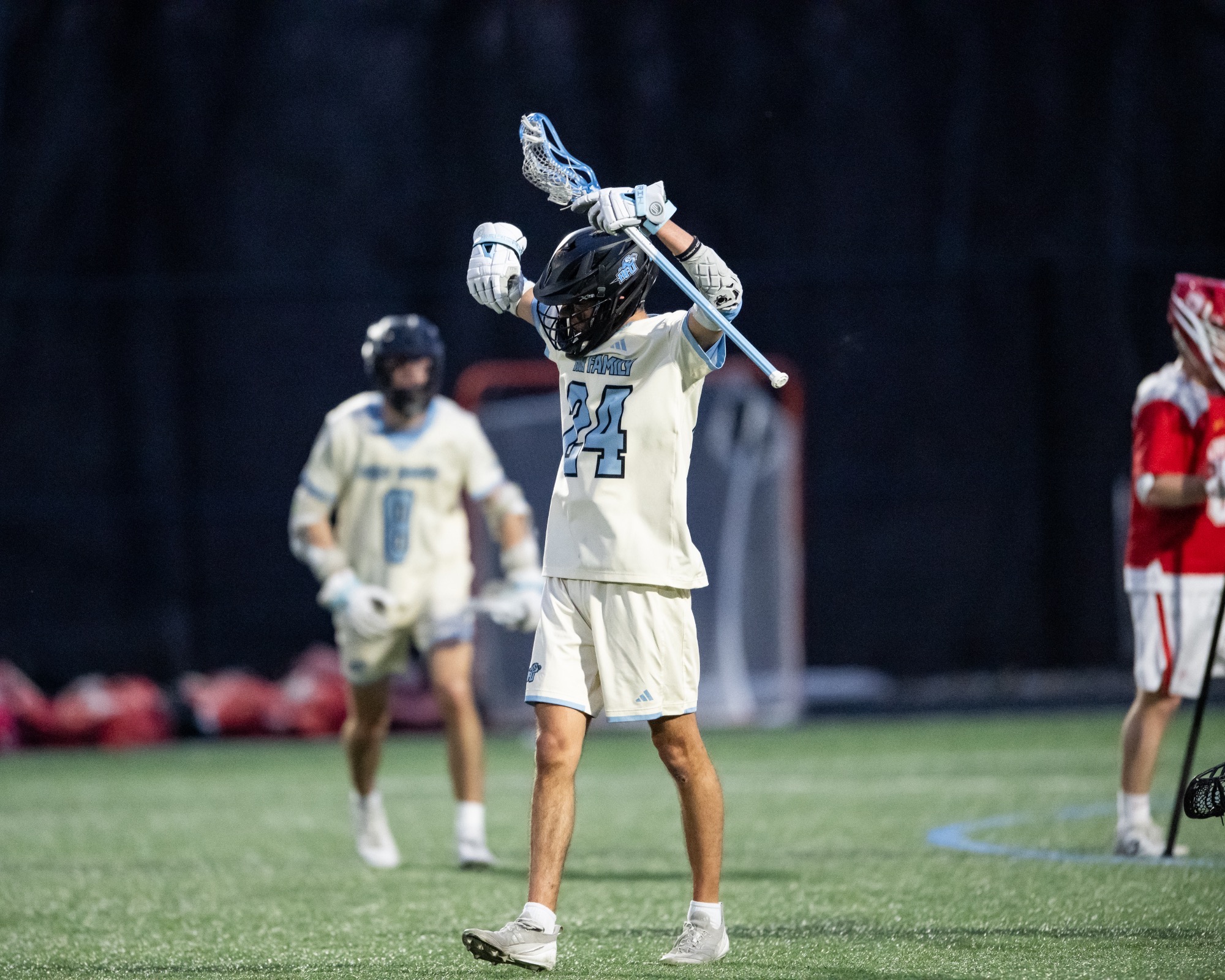 James Bienia celebrates after scoring, his hands up in the air with his stick in his left hand