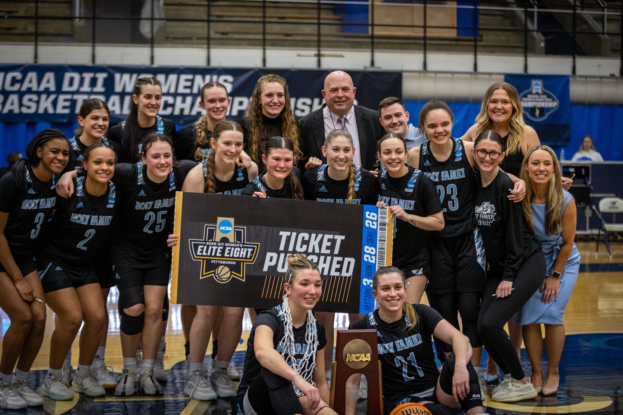 The 2025-26 HFU Women's Basketball Team takes a group photo with the 2026 East Region Champion trophy