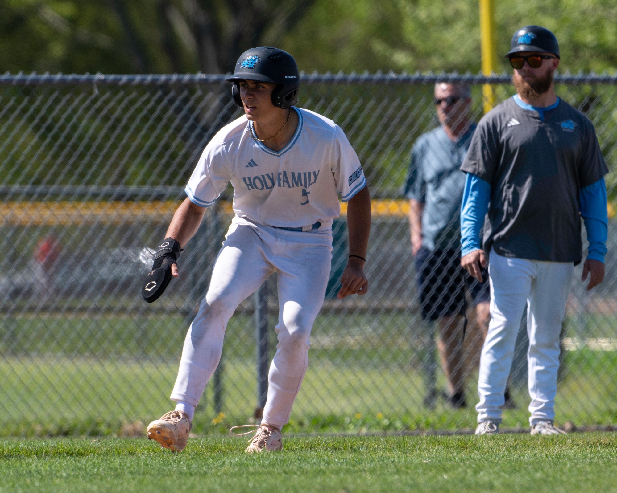 Stephen Furia leads off third base, with third base coach Robert Kraft watching on from behind 
