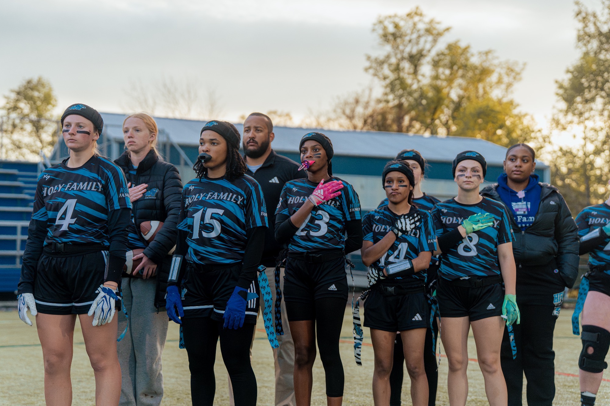 The HFU Flag Football Team standing on the sideline during the national anthem 
