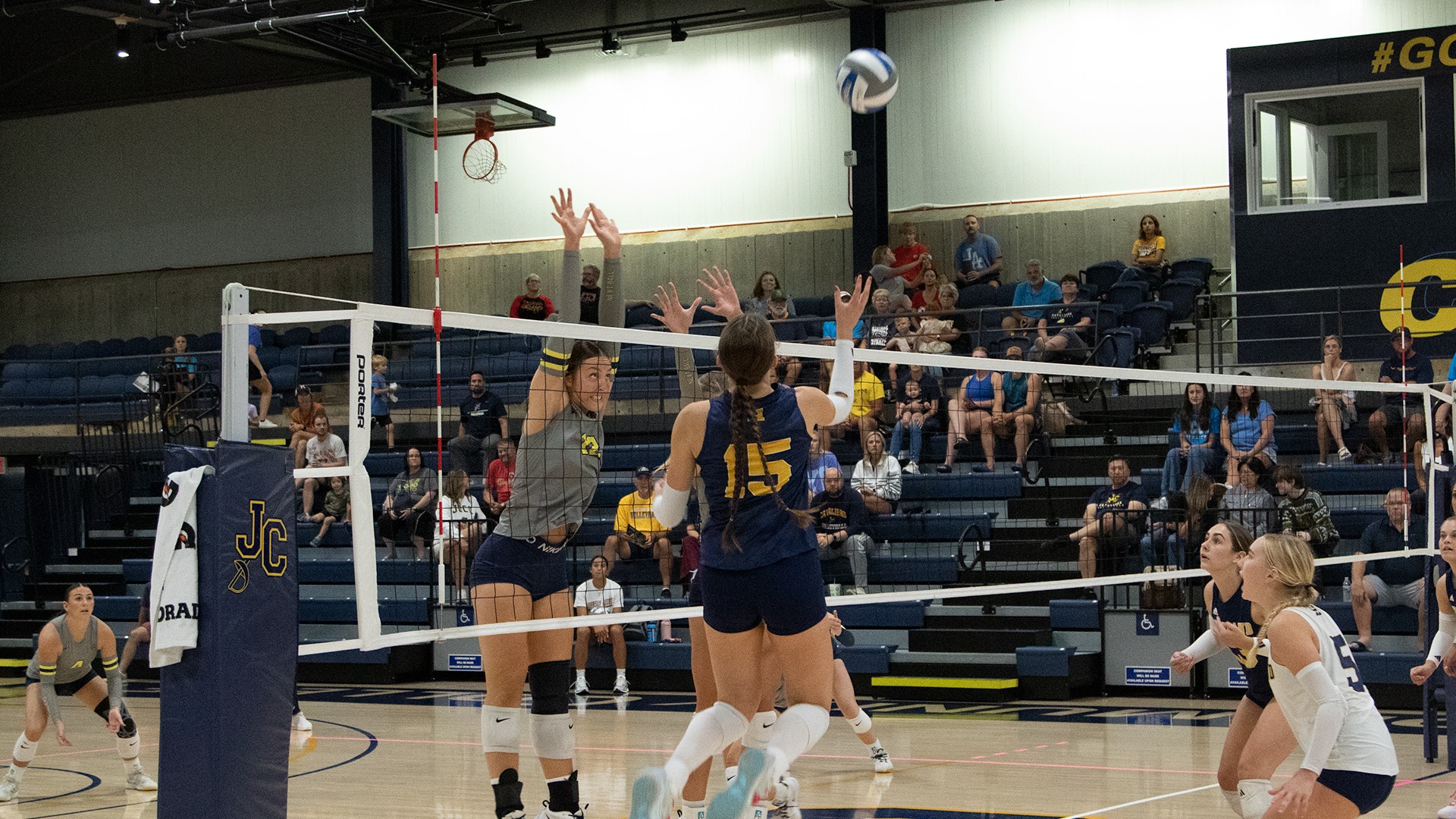 Cali Honeyman (15) floats a kill shot over a pair of Johnson County defenders