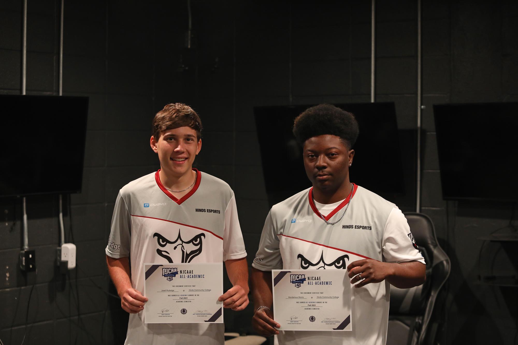Two eSports players posing with certificates