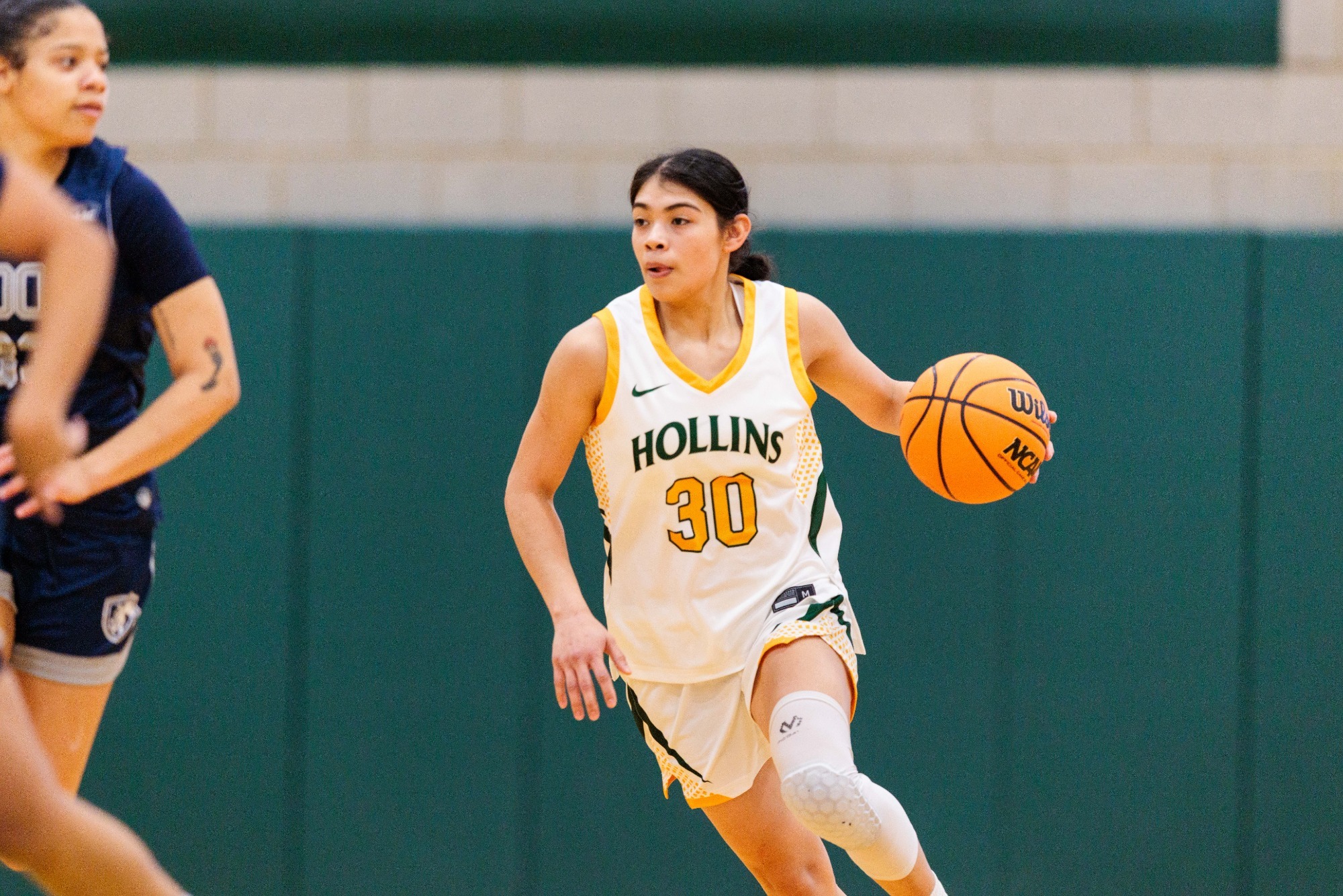 Sarah Morales bringing the ball up the floor against a defender