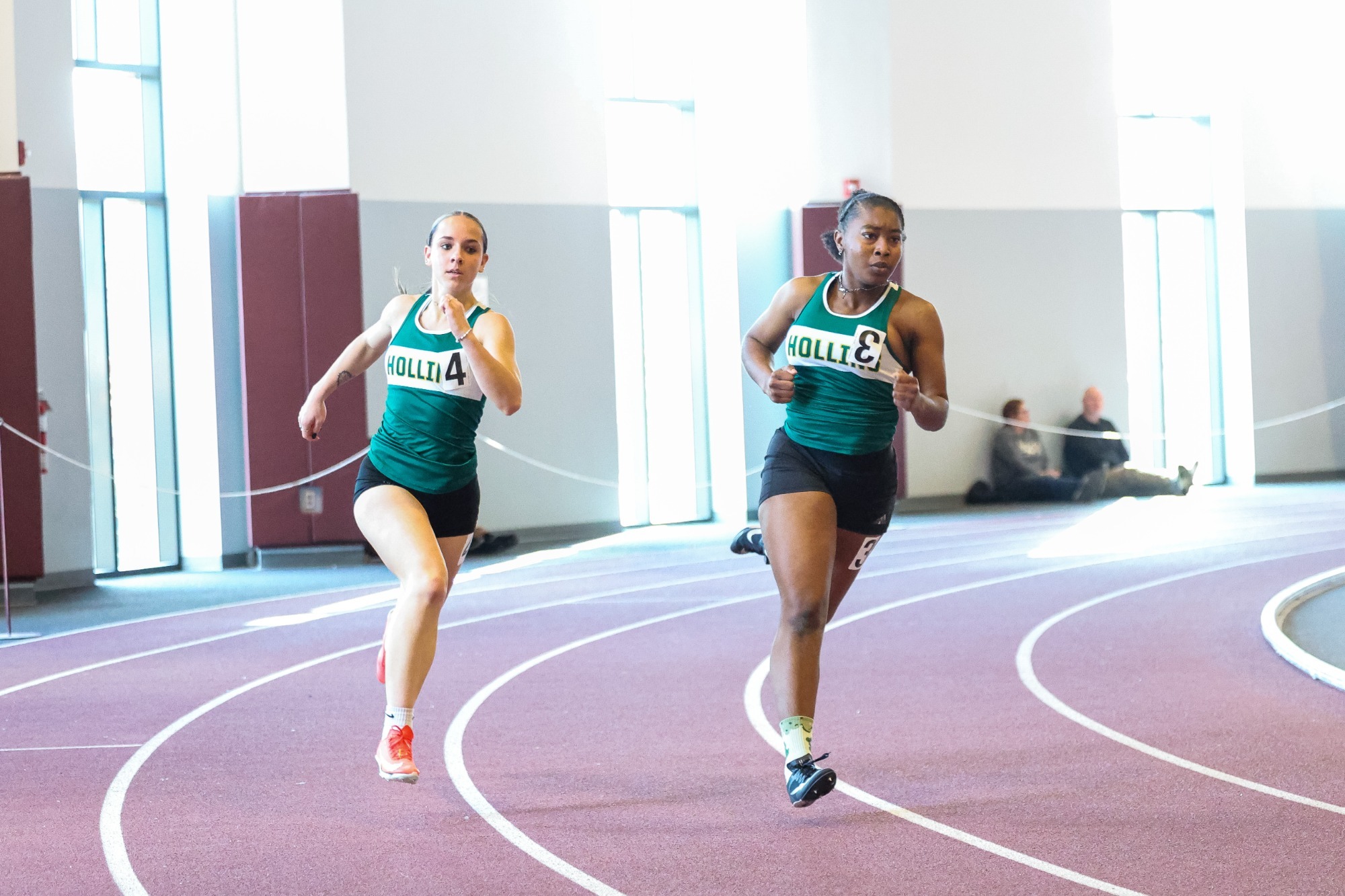 Pair of Hollins runners in an indoor sprint race