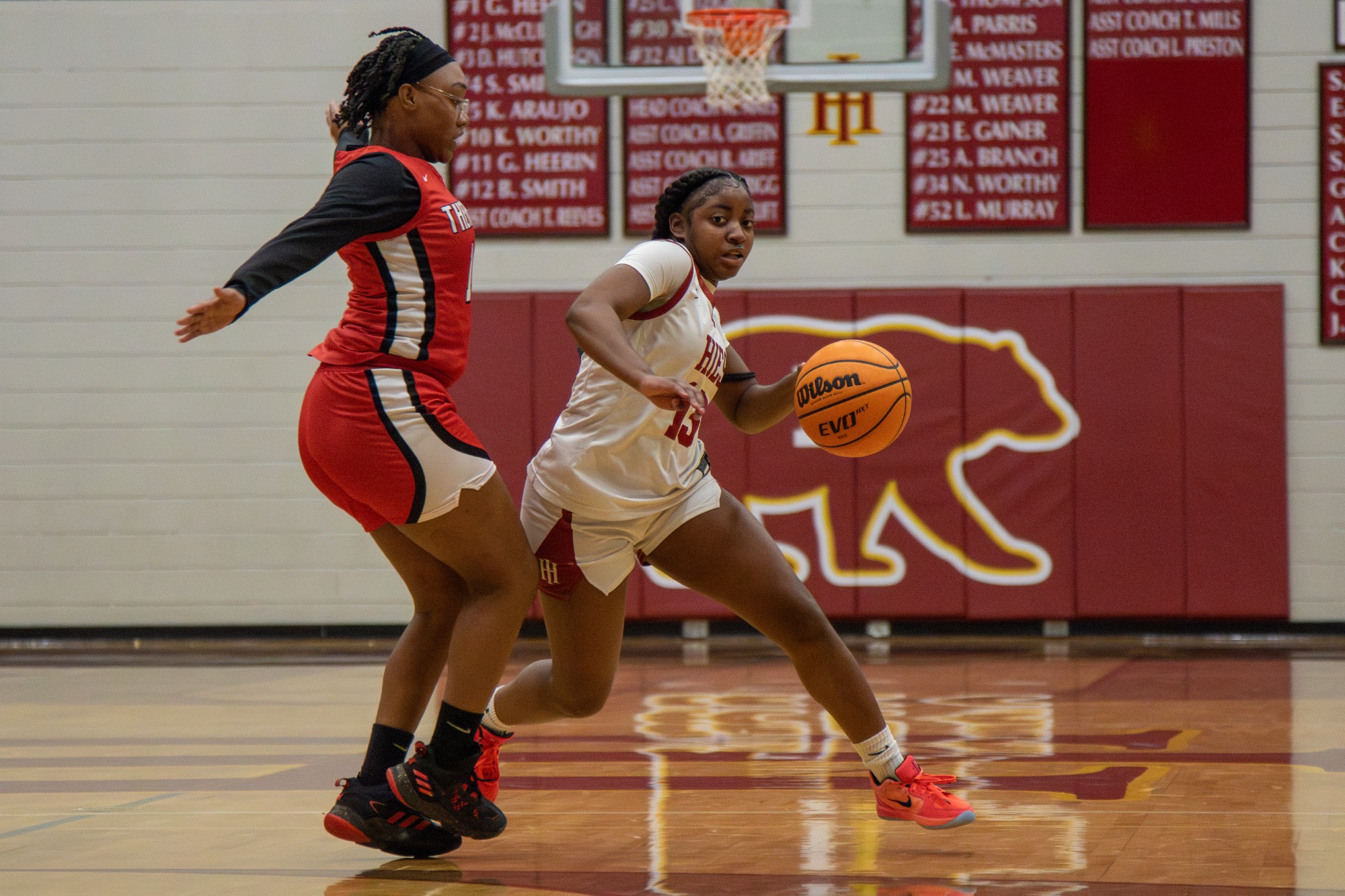 Holy Innocents’ girls varsity basketball players compete against Therrell during a home game, showcasing in-game action, defense, and scoring opportunities.