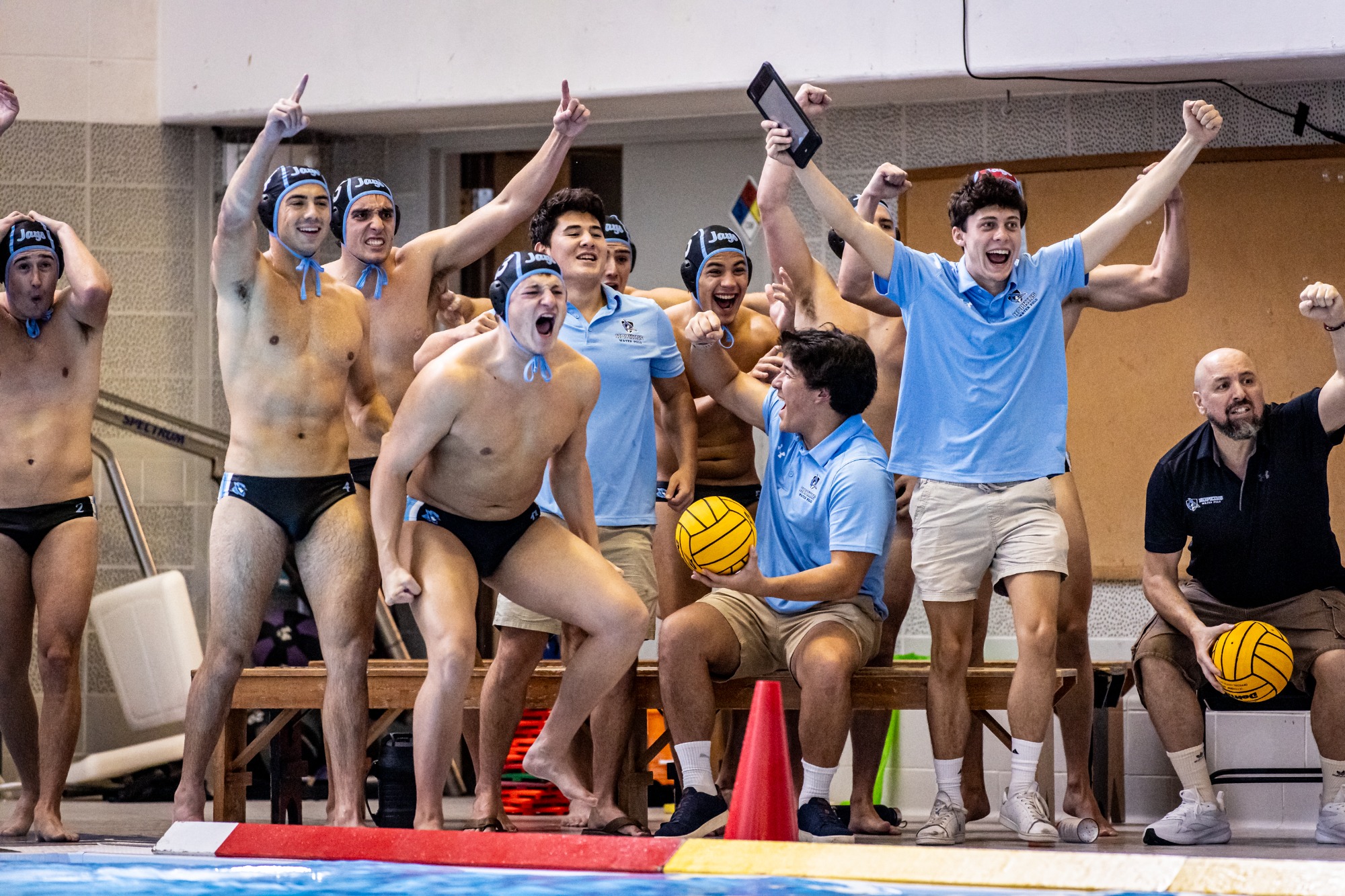 The bench celebrates during a 13-8 win against George Washington.