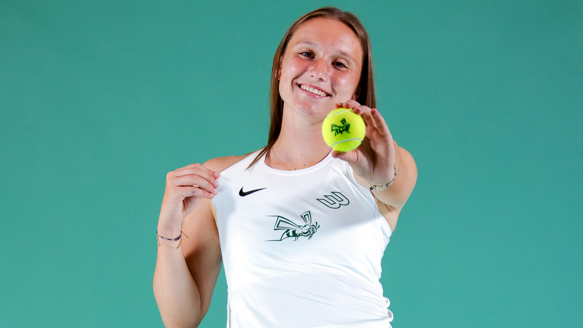 2026-27 WTEN Nel Van Hout media day photo holding a tennis ball with the Hornets' logo on it