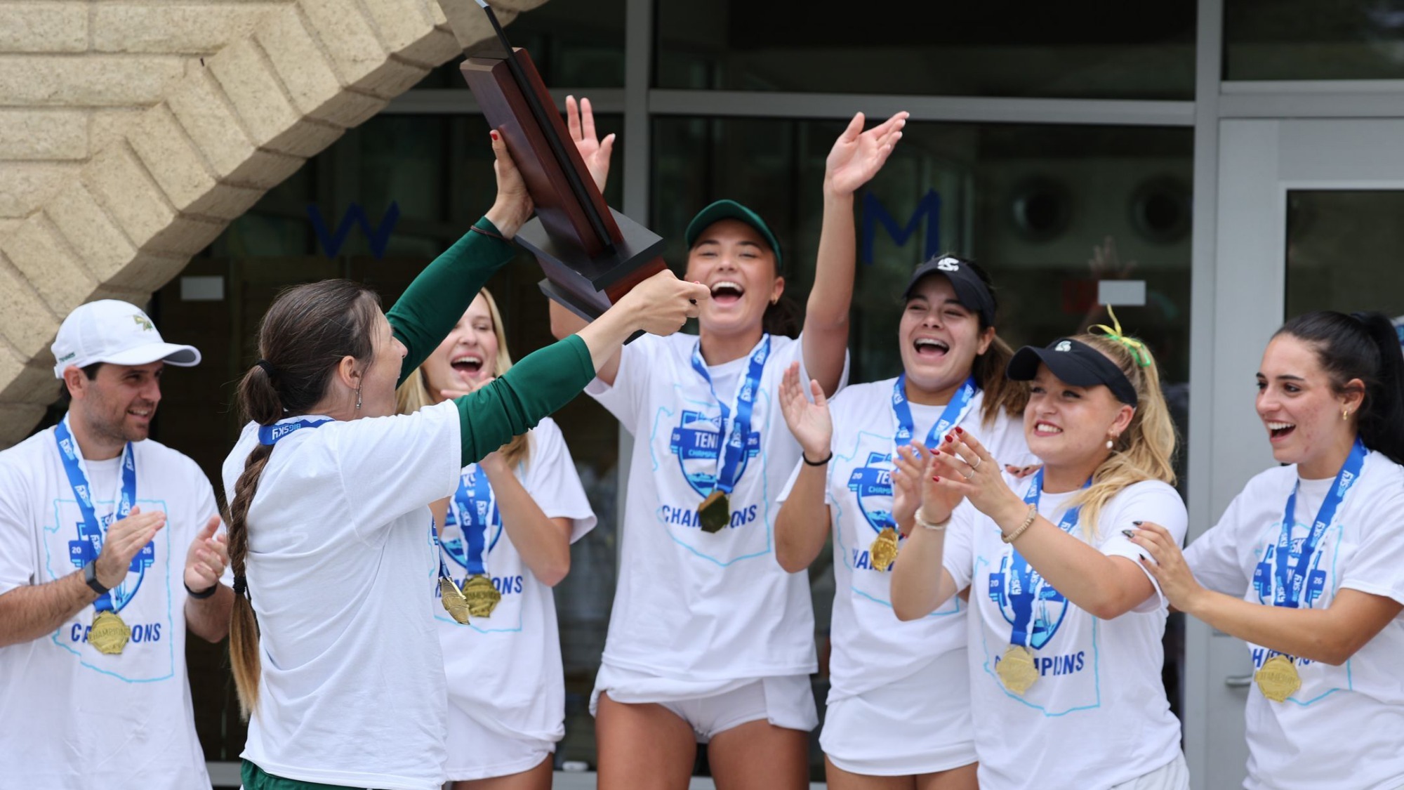 2025-26 WTEN Head Coach Sophie Breault presents the Big Sky Conference Tournament trophy to the team following their win over Northern Arizona in the championship match