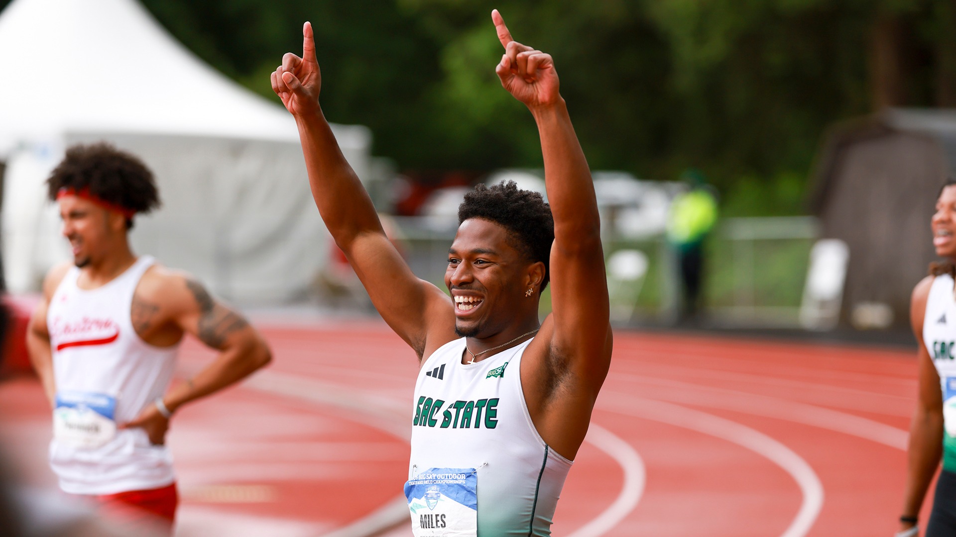 Gianni Miles raises both arms to celebrate following his race