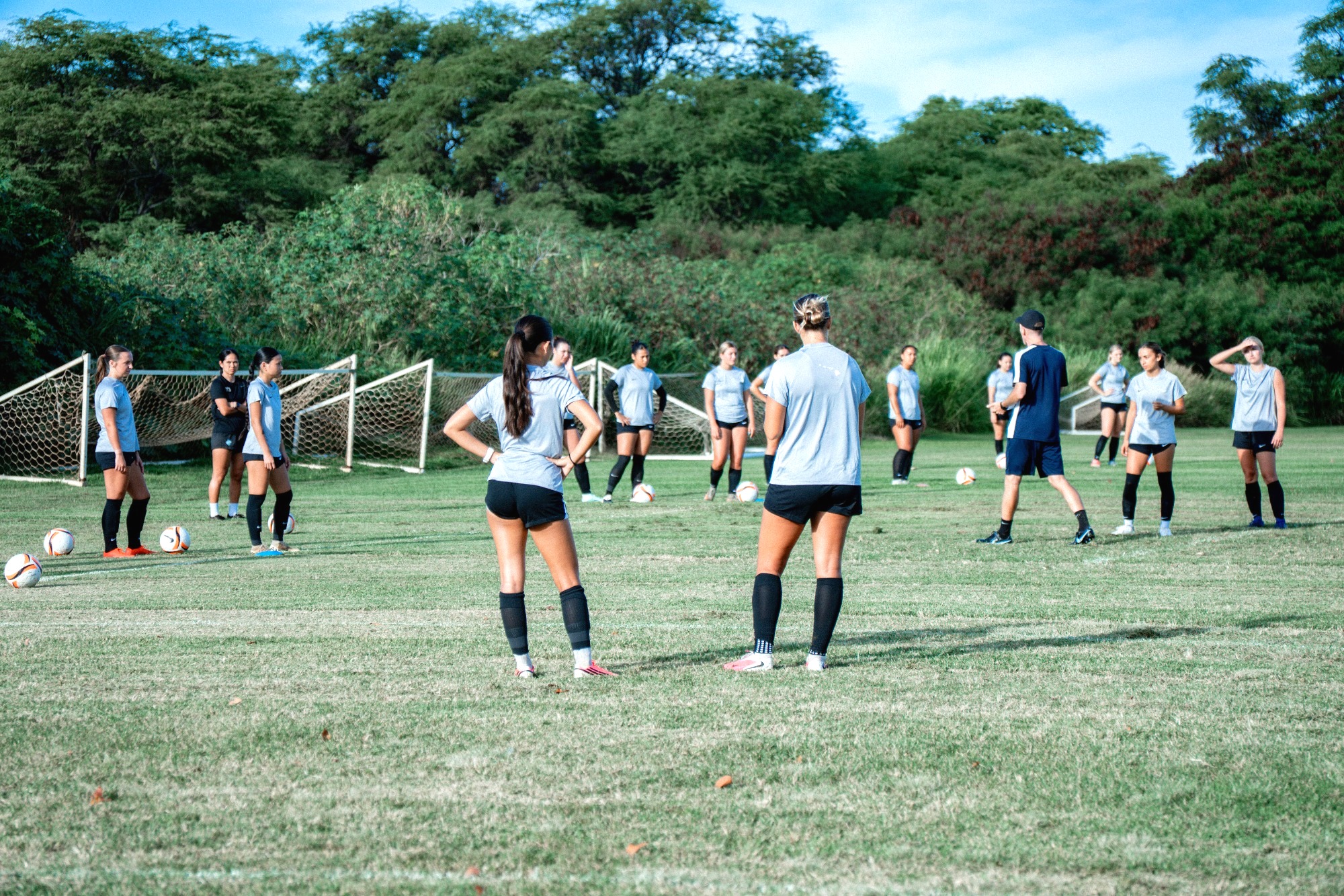 Women's begin training, players are going through a drill lead by Coach Artigue