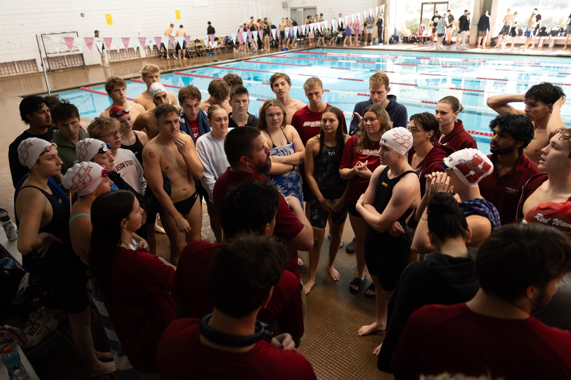 Red Wave Swim gathers around Coach Scotty Serio for pre-meet instructions.