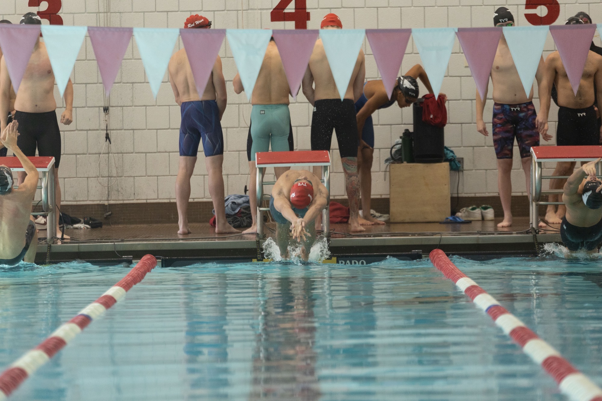 A swimmer dives into the pool to begin a race at Henderson's Duke Wells Natatorium