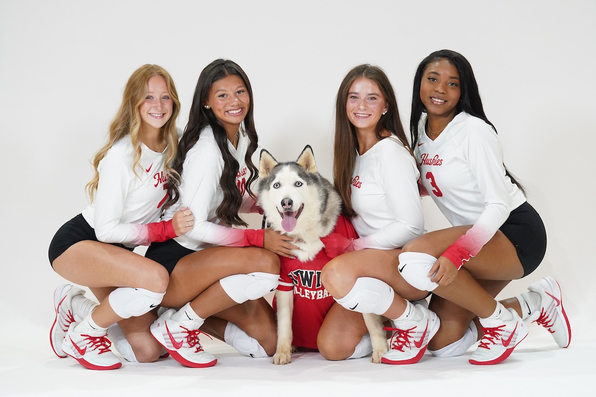 Four volleyball players with dog 