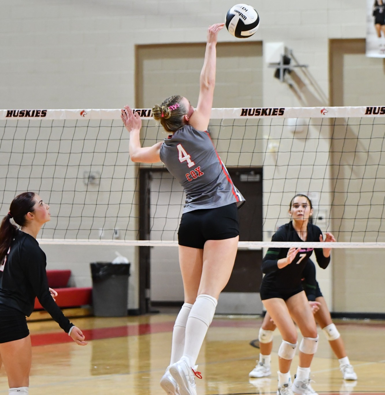 Volleyball player spikes ball 