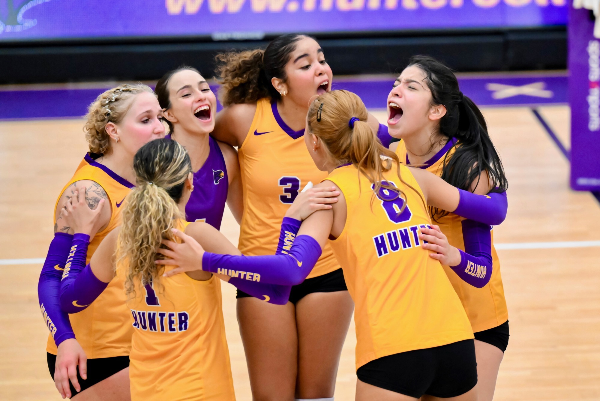 Hunter women's volleyball team huddles after a point.