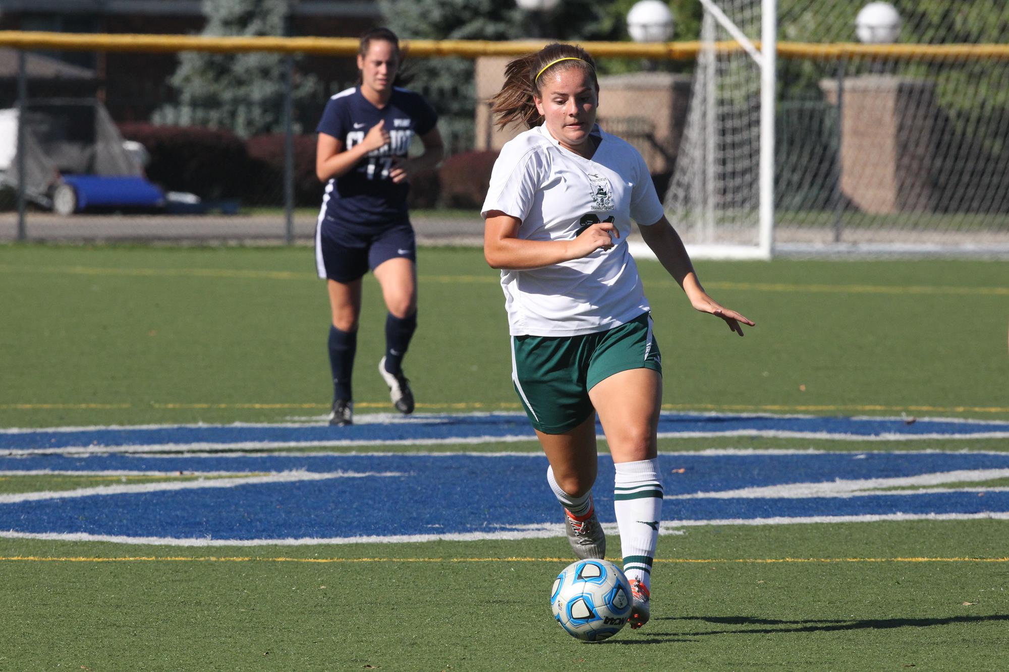 Abdalah runs soccer ball away from opponent