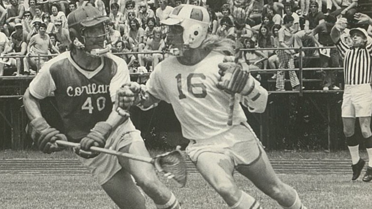 Beaver Draffen cradles the ball while being guarded by a Cortland player.