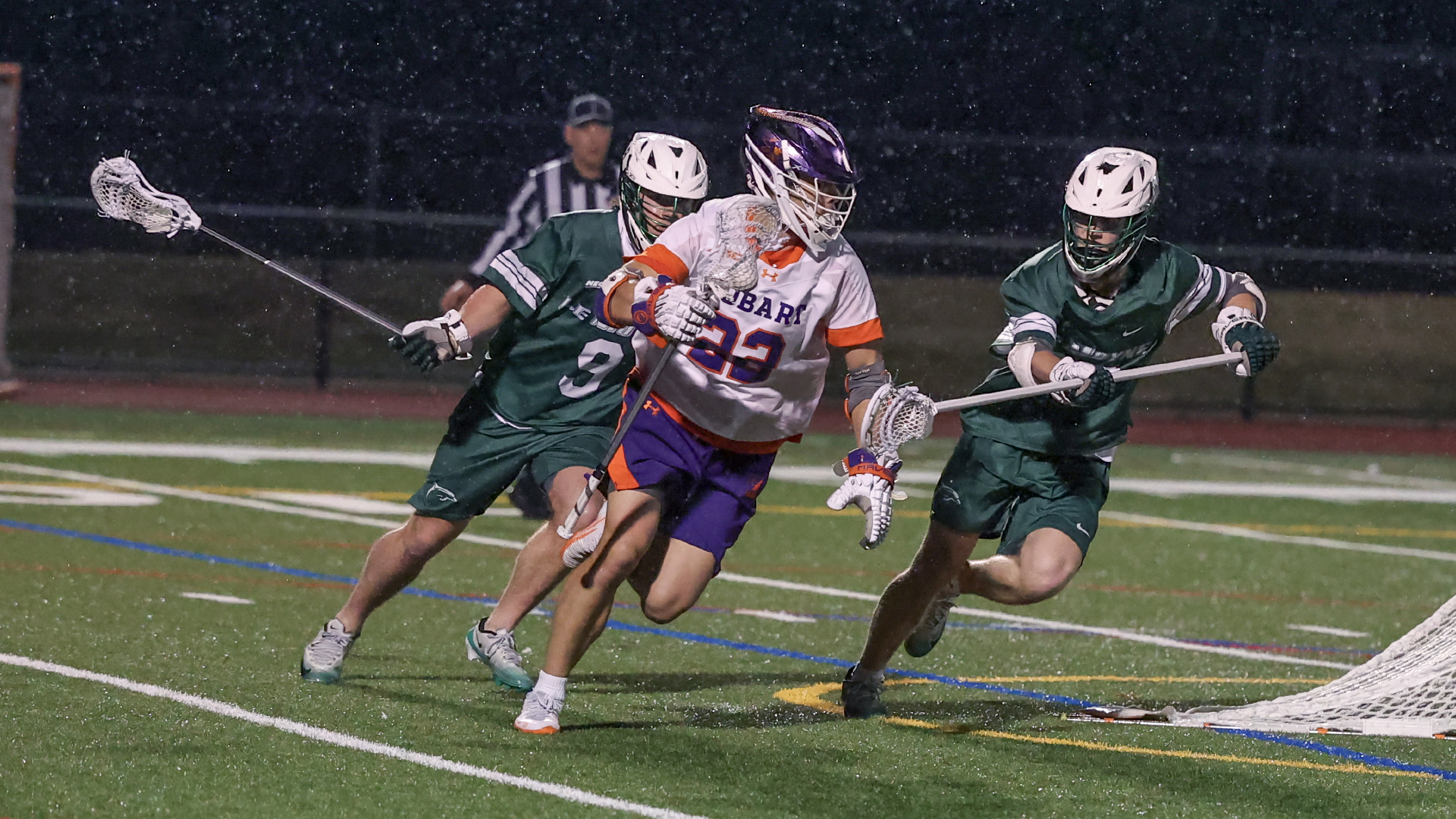 David Peterkin runs behind the goal, pursued by a pair of Le Moyne defenders.