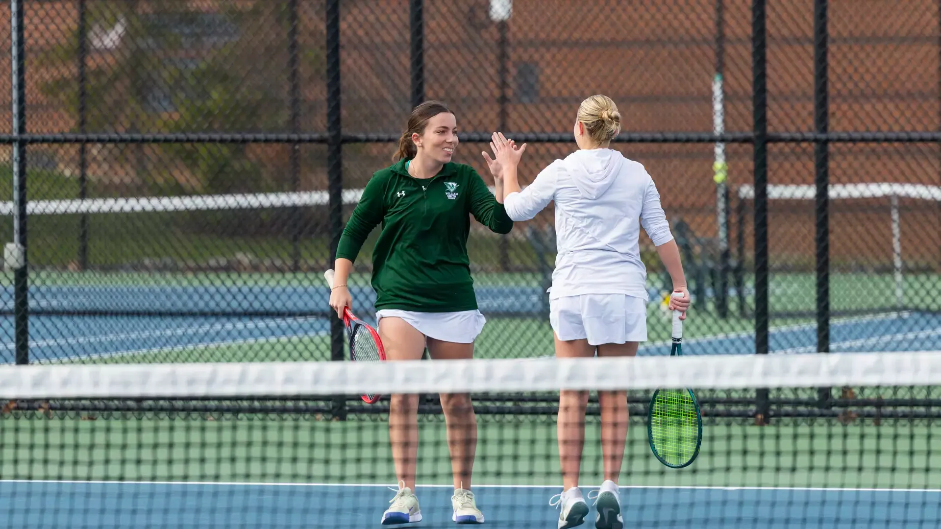 Mae Kellersman and Bethany Walker high five in doubles 