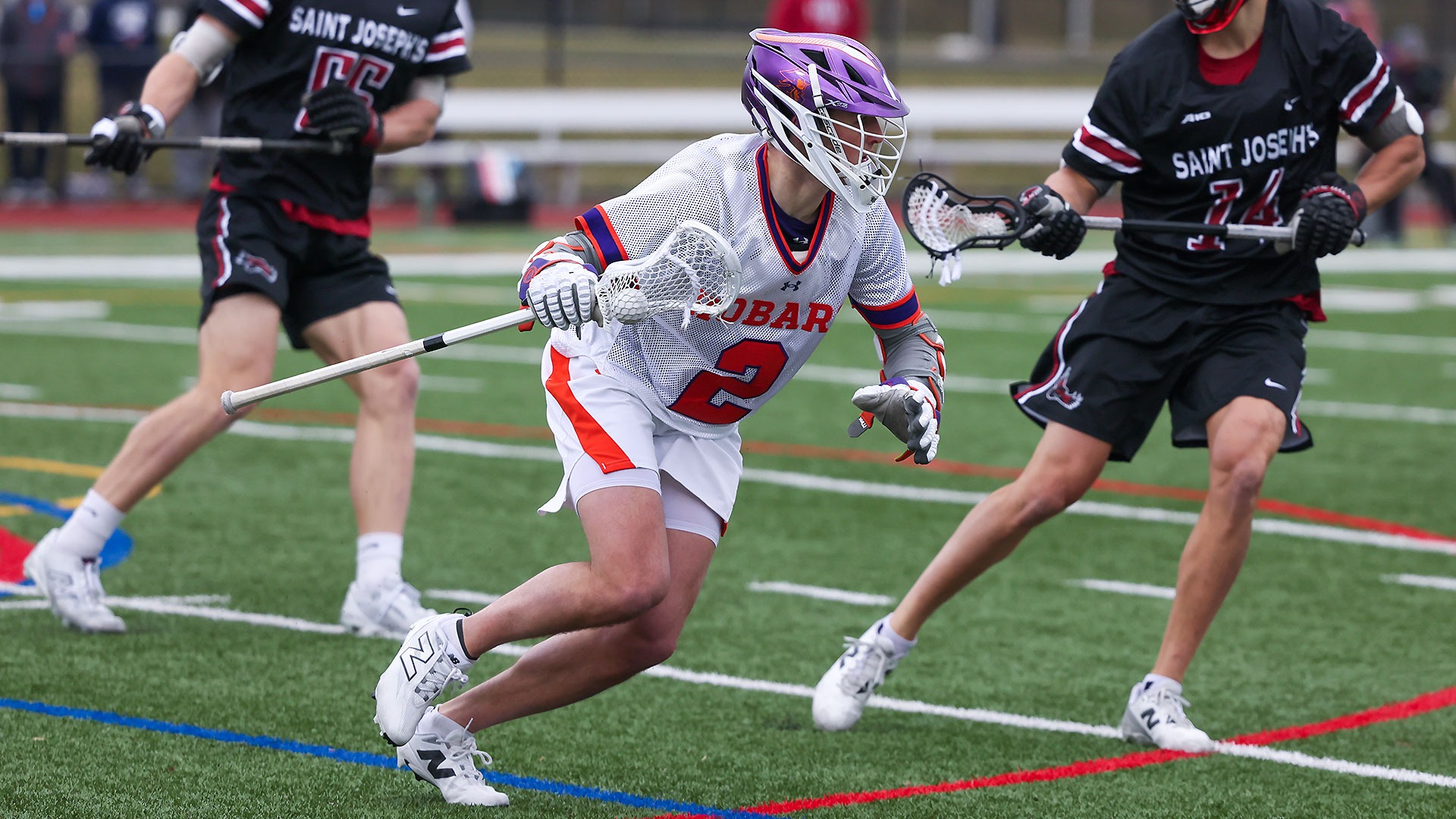 Slade Englstrom cradles the ball while being shadowed by a Saint Joseph's defenseman.