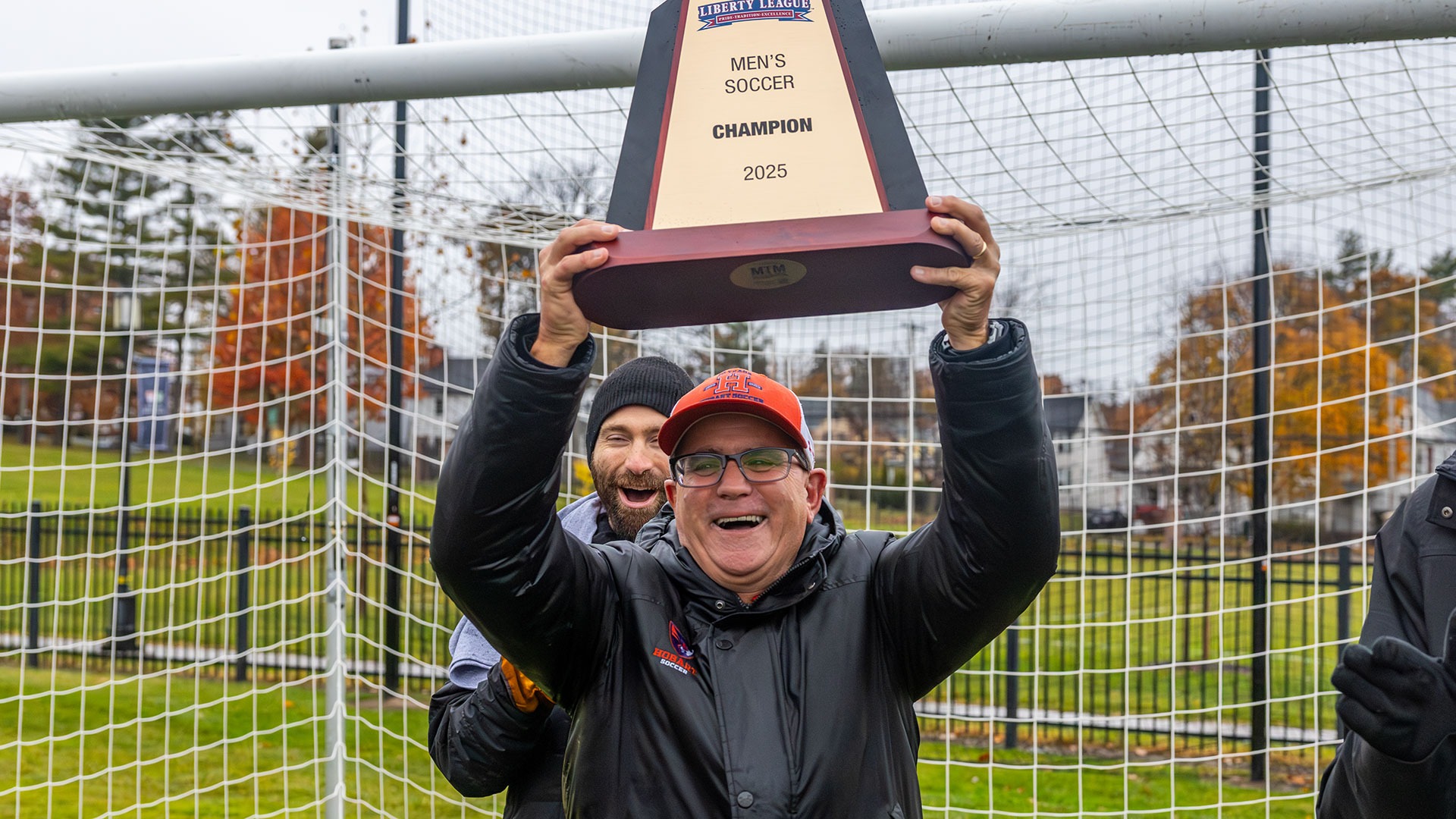 Shawn Griffin holds up the 2025 Liberty League Championship Trophy.