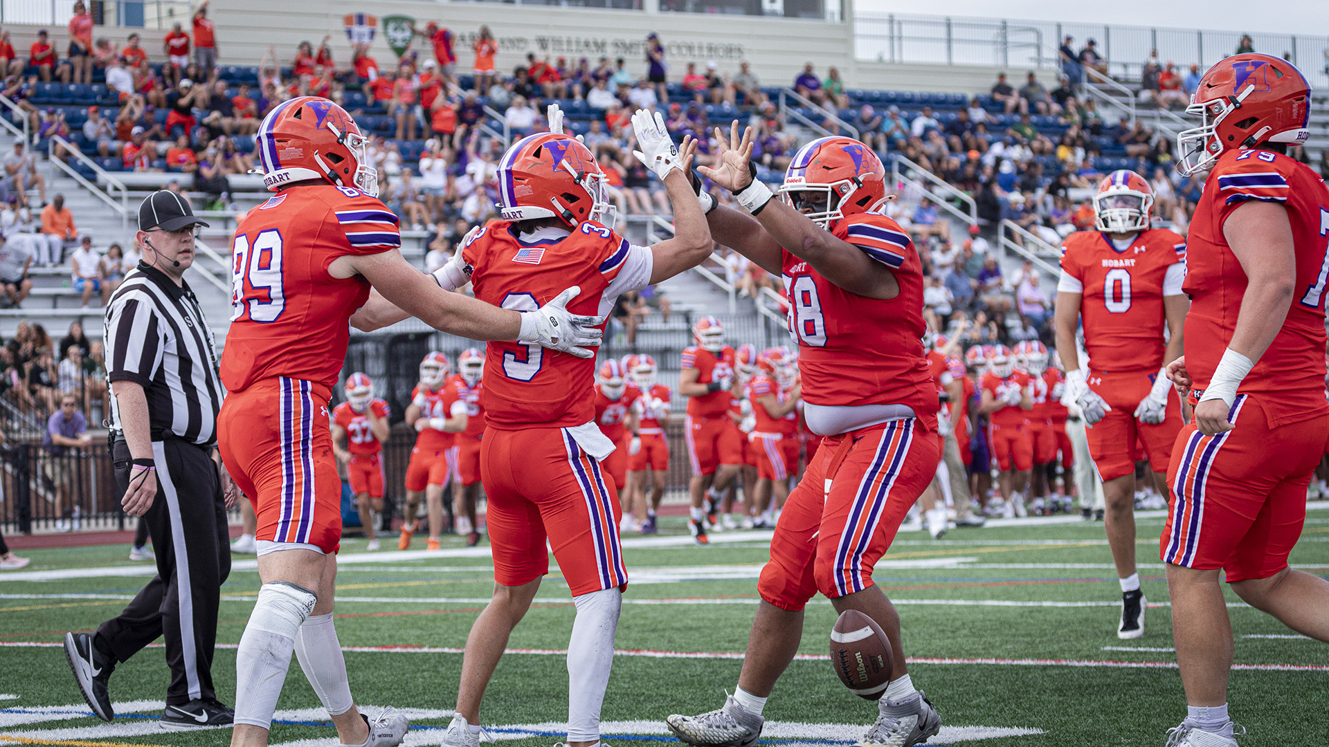 Timothy McKeever (#89) and Javon Hricenak-James congratulate Johnny Harding (#3) on his touchdown catch.