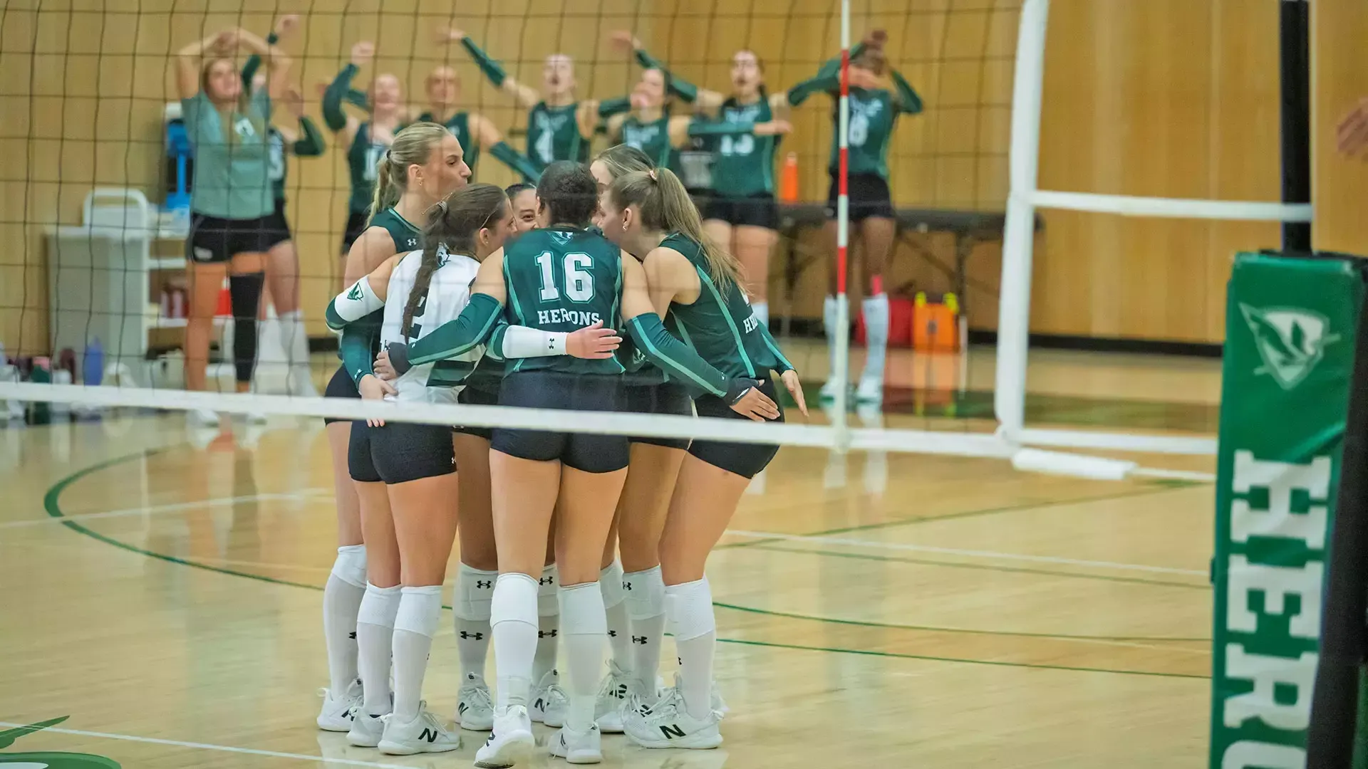 William Smith volleyball huddles together