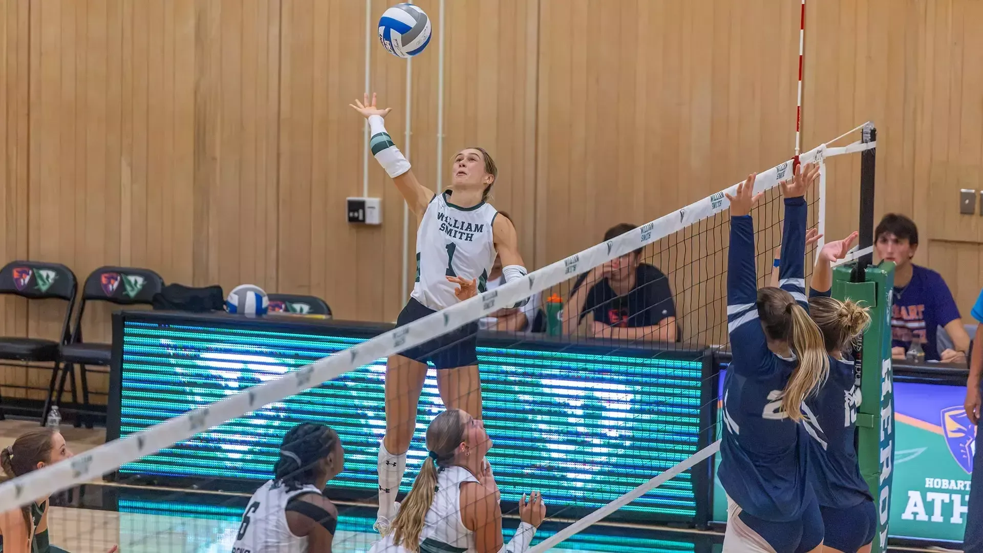 Cassidy Breuer jumps high to reach and return the ball