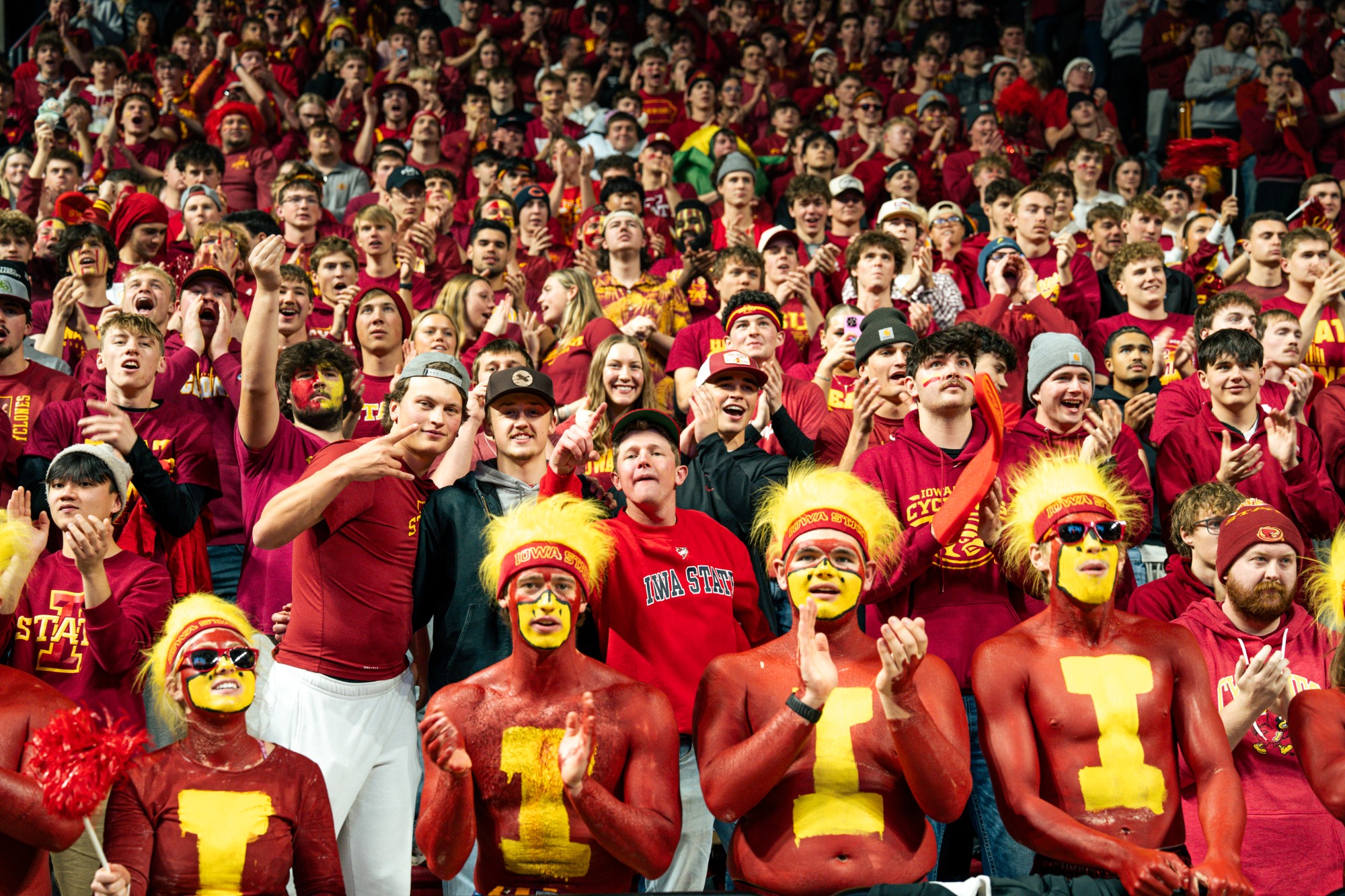 Students with painted chests cheering in Cyclone Alley