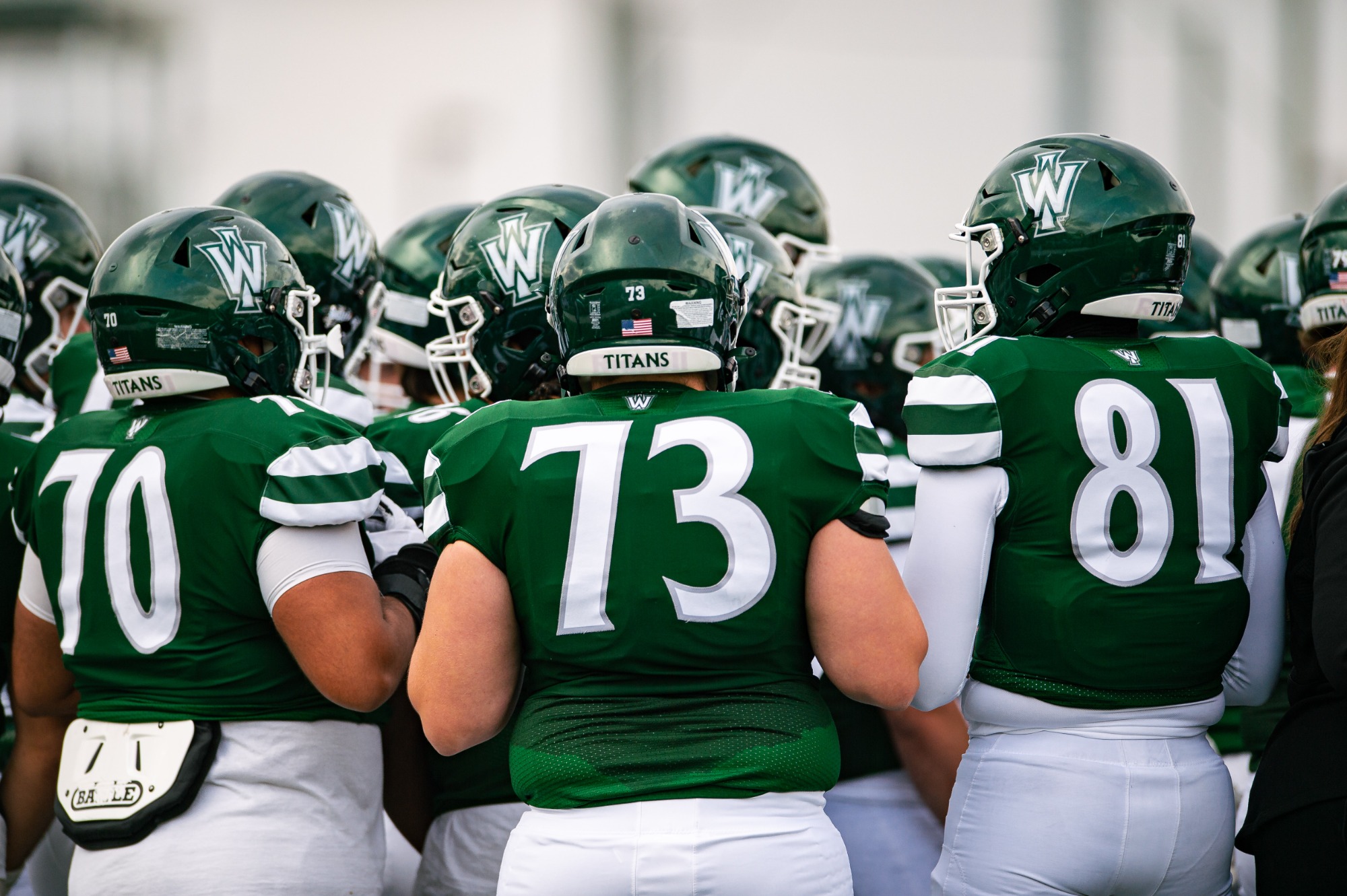 Football huddling up vs. Carroll