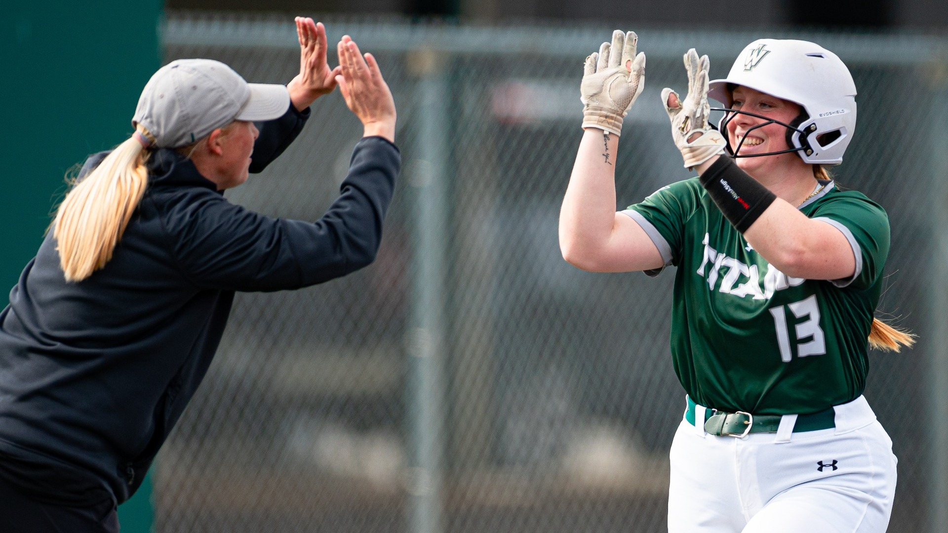 Claire Post & Tiffany Prager high five to celebrate a home run