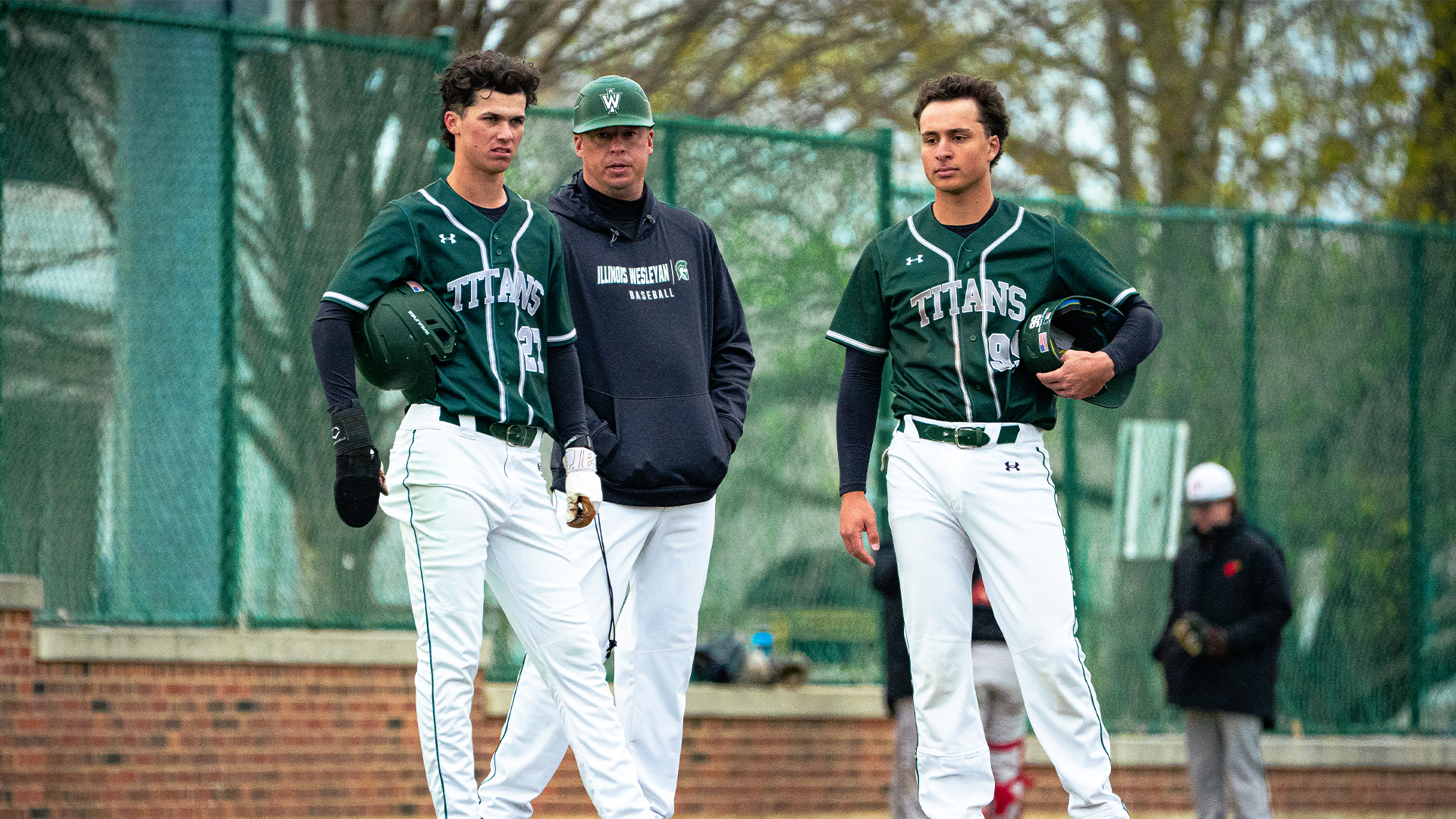 Eli Kieser and Anthony Batchon wait at third base with head coach Michael Kellar 