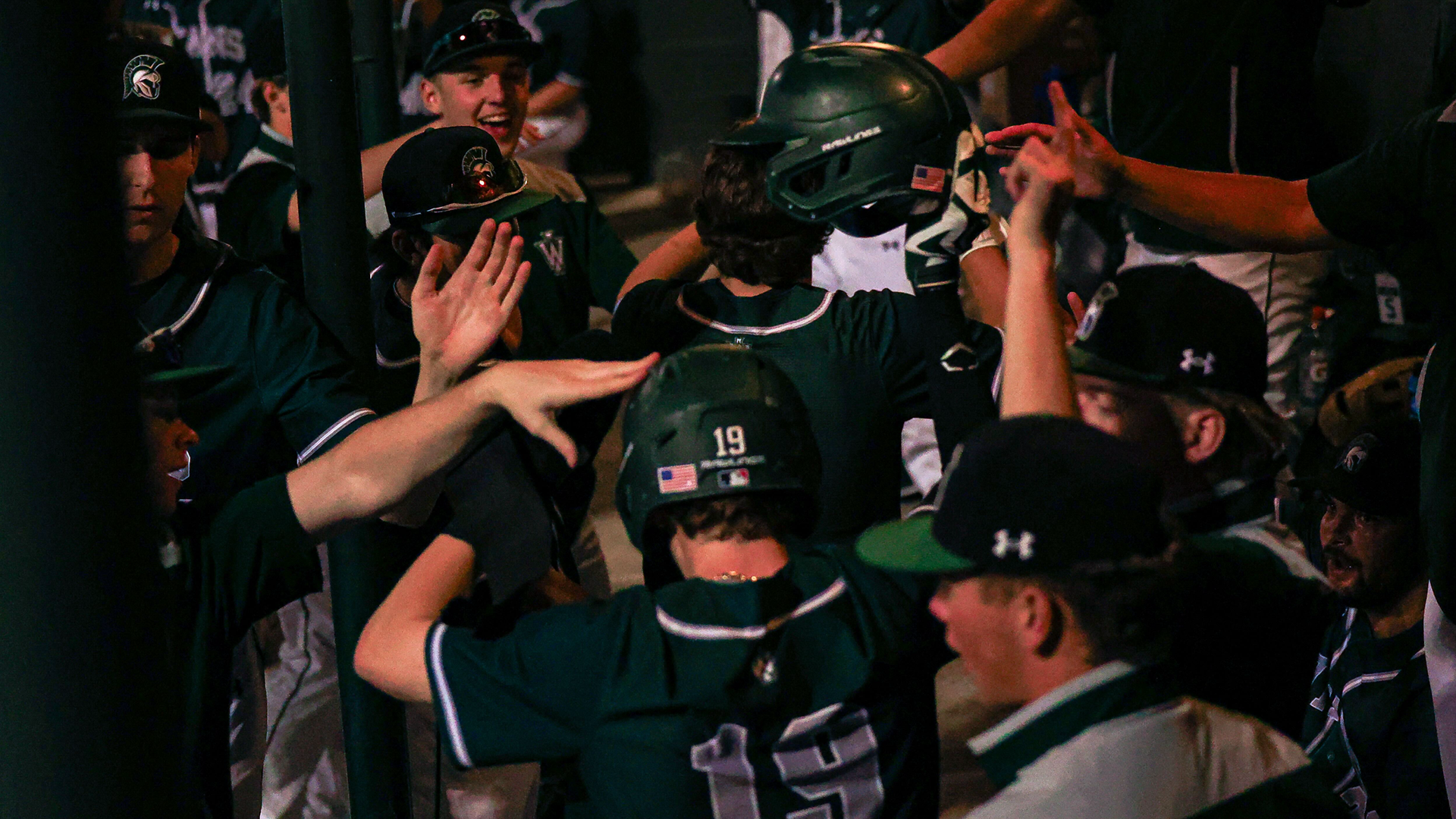 Crowded Dugout high fives Hudik who scored 