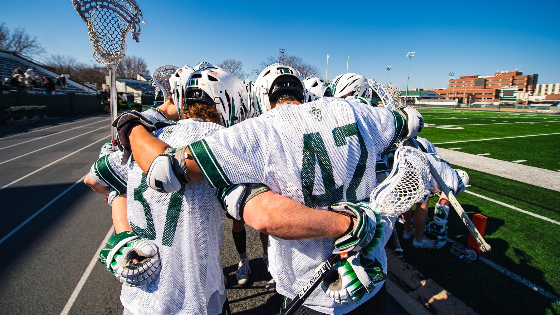 Men's lacrosse players huddled pregame