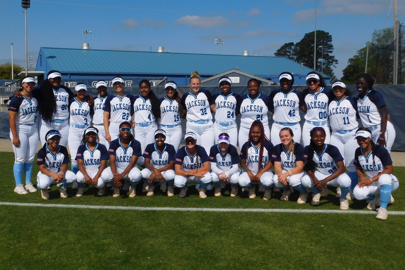 Jackson State softball team picture; wearing THEEiLove blue and white jerseys at the JSU Softball Field