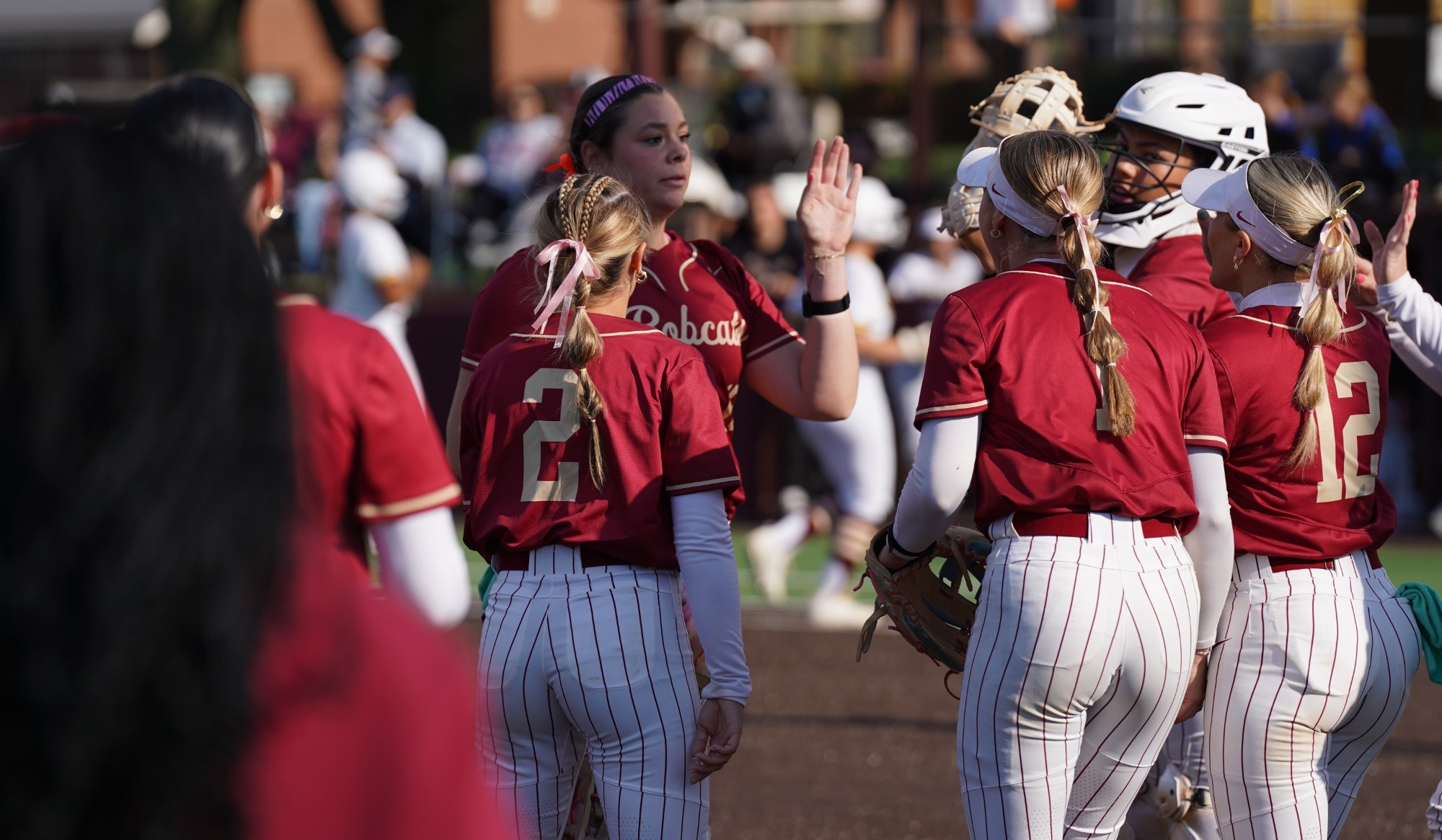 madison sawyer high fives her teammates after a strikeout