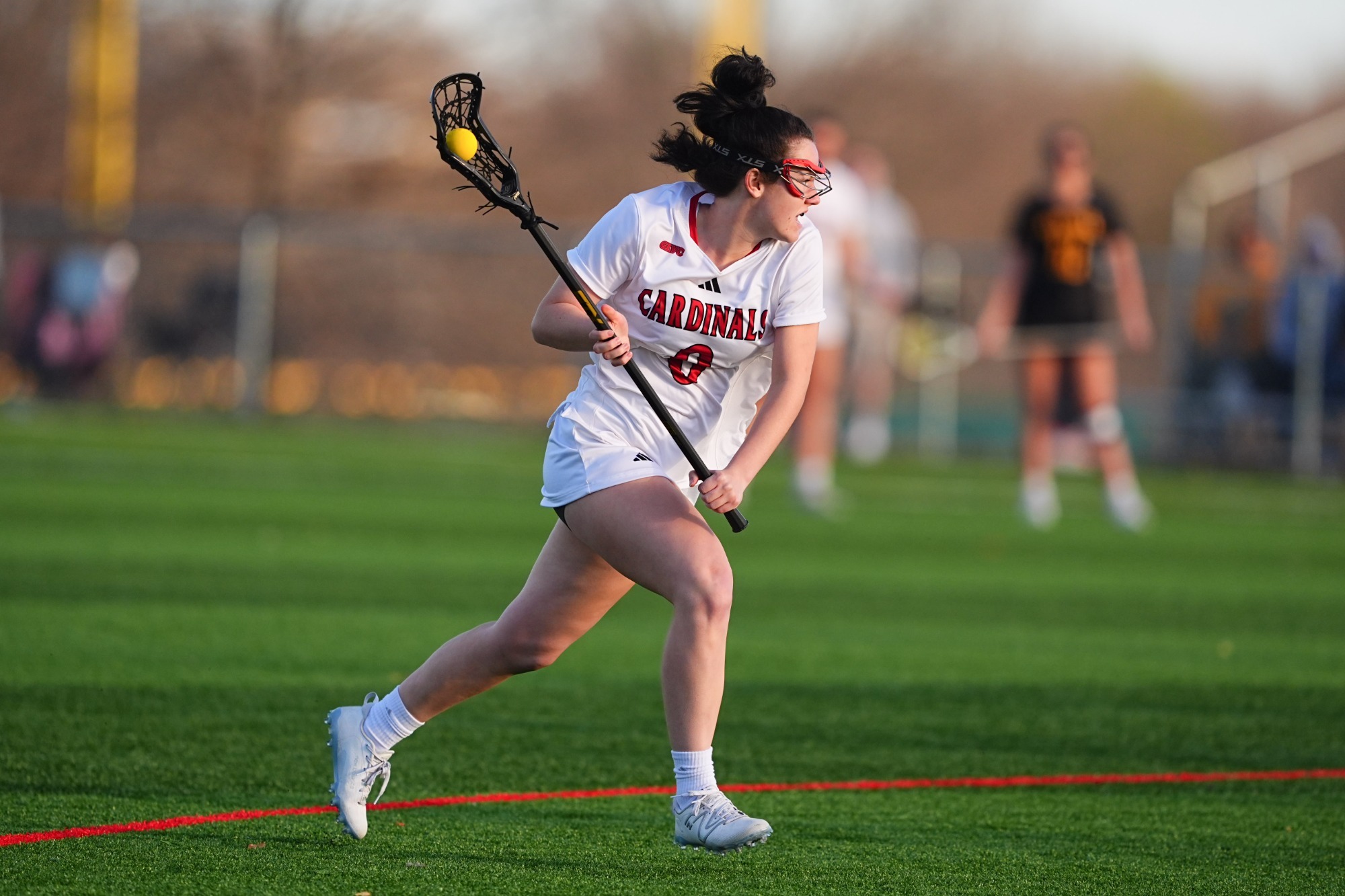 Kaylee Gross running with stick