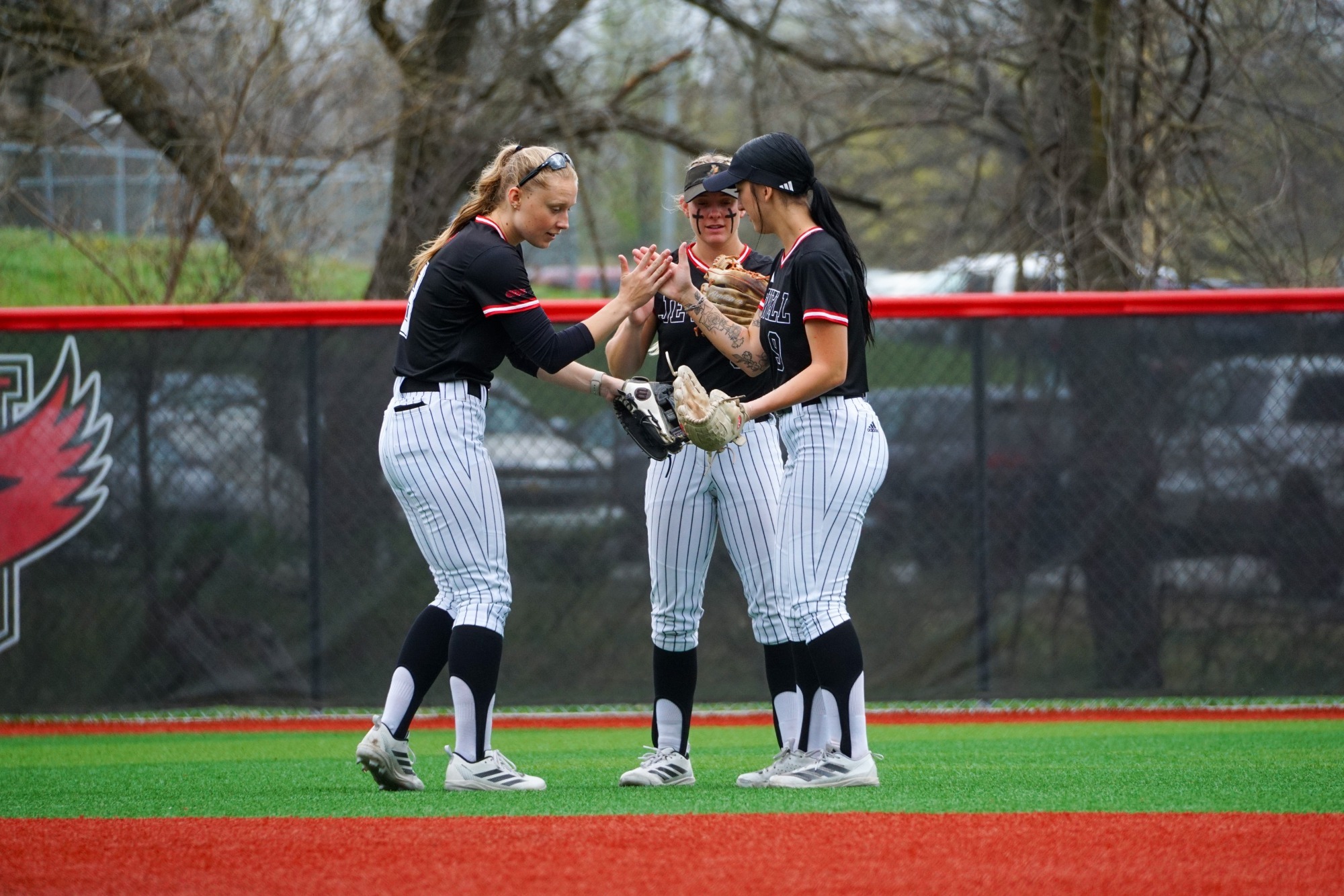 three outfielders giving high fives in a circle
