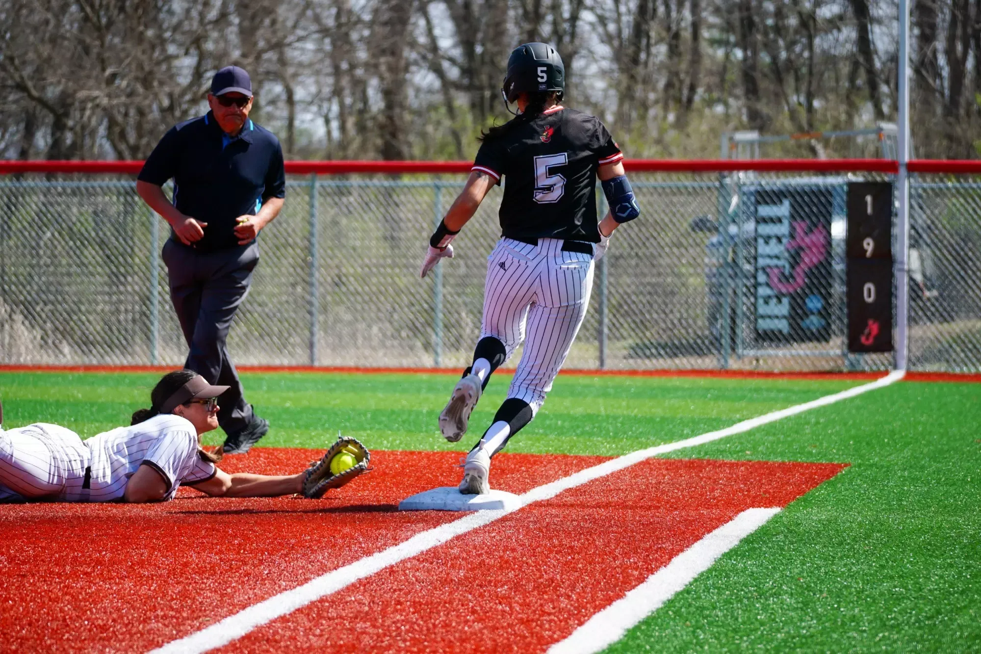 Softball player running through first base 