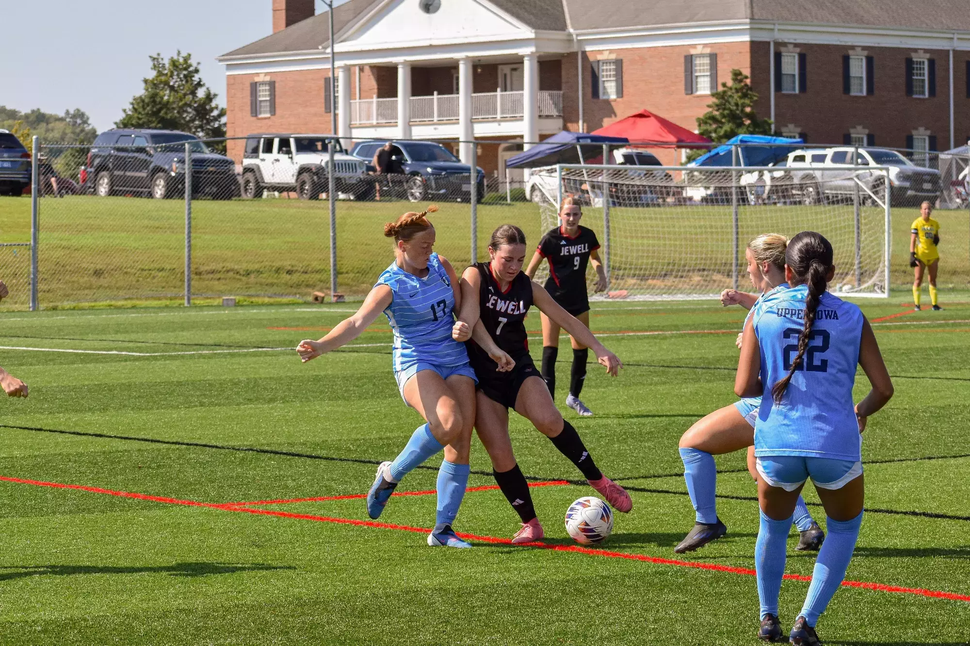 Allison Schwarz fights for a header in a black Jewell soccer jersey against a player from Upper Iowa in light blue uniform