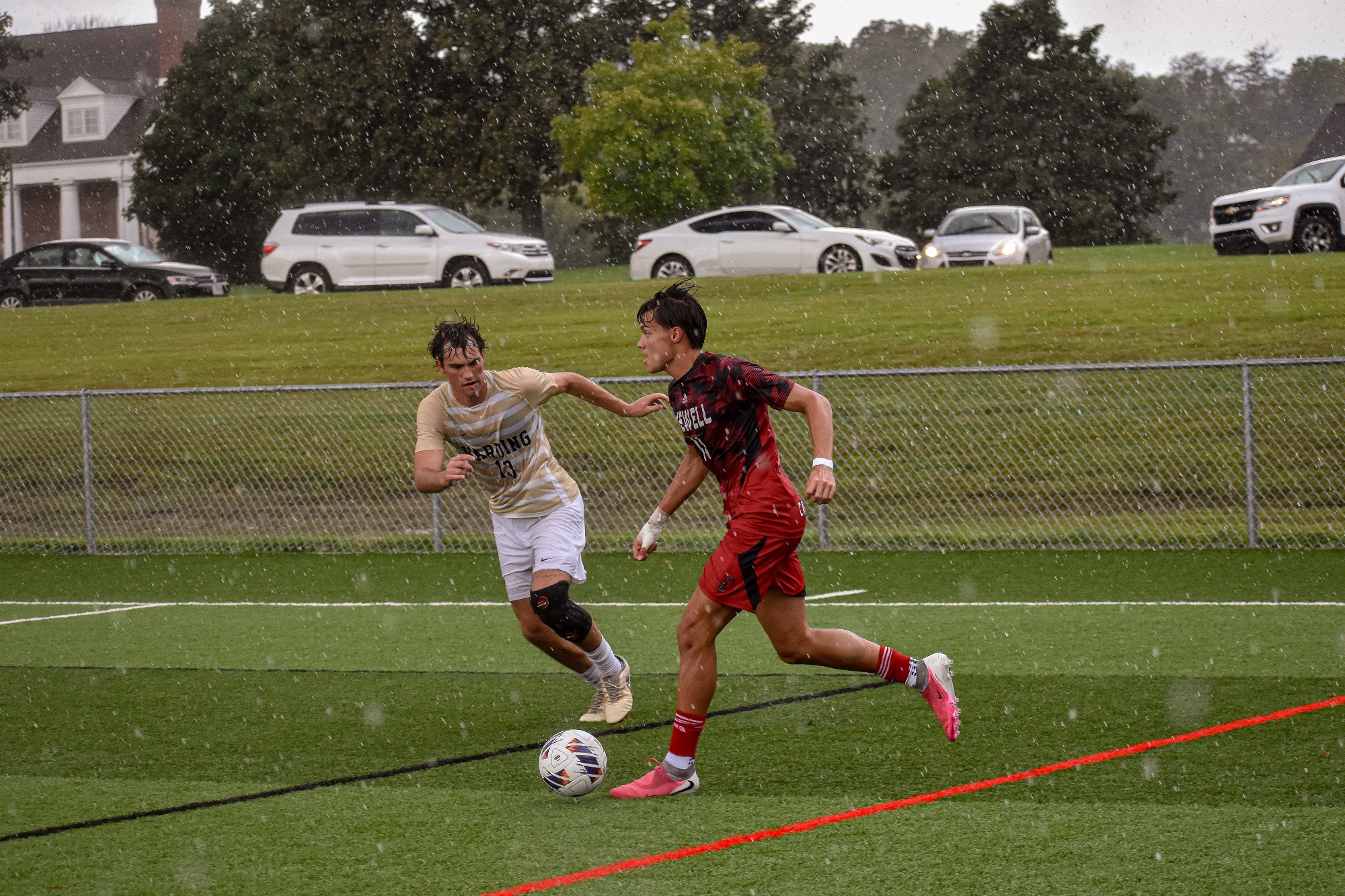 Owen Pereira dribbles past a defender in the rain against Harding