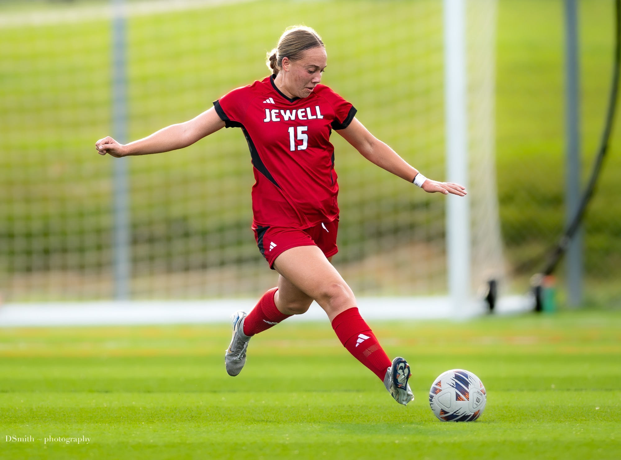 Briana Maytas winds up to kick a soccer ball while wearing a red Jewell uniform