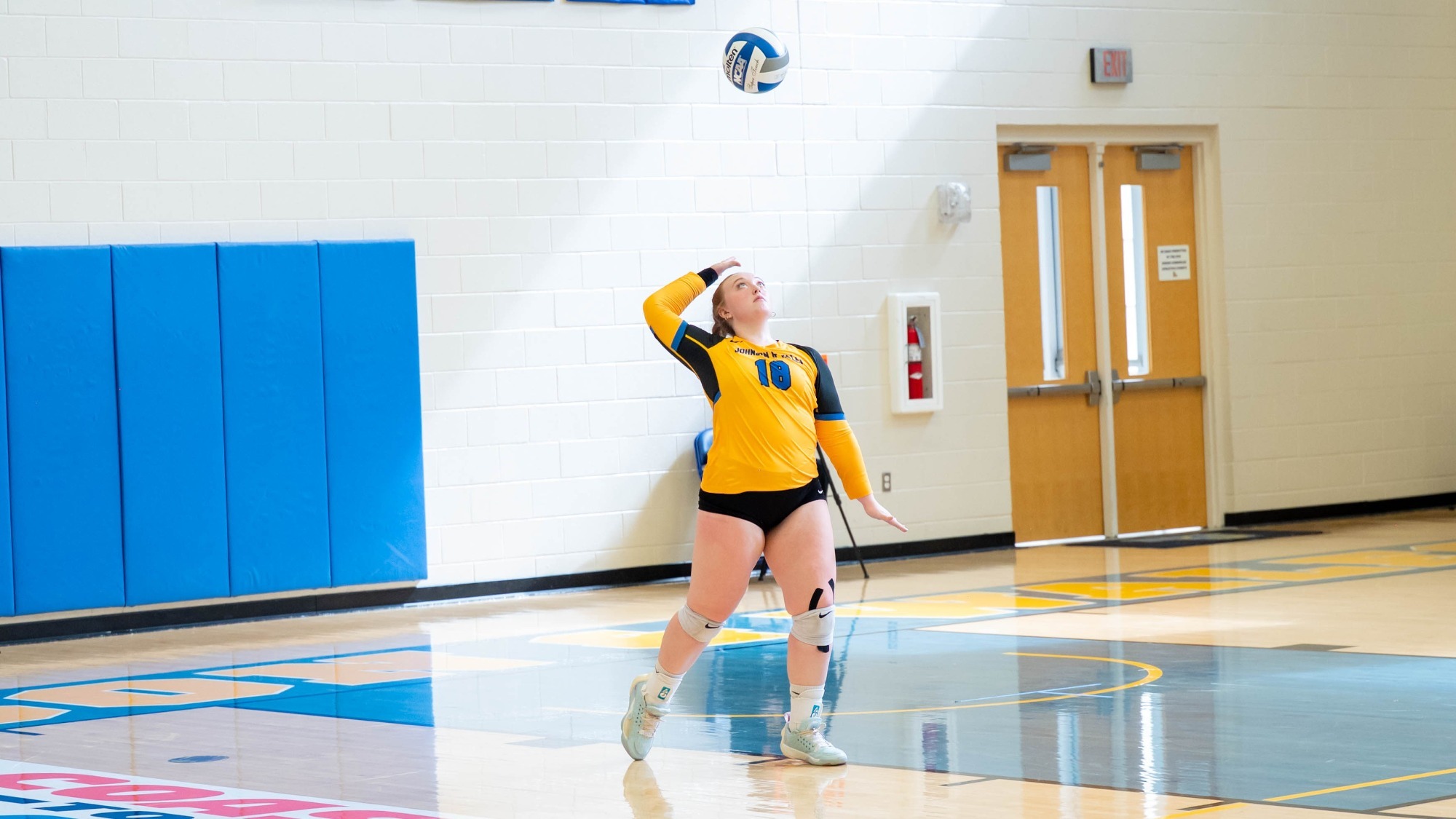 woman serving a volleyball