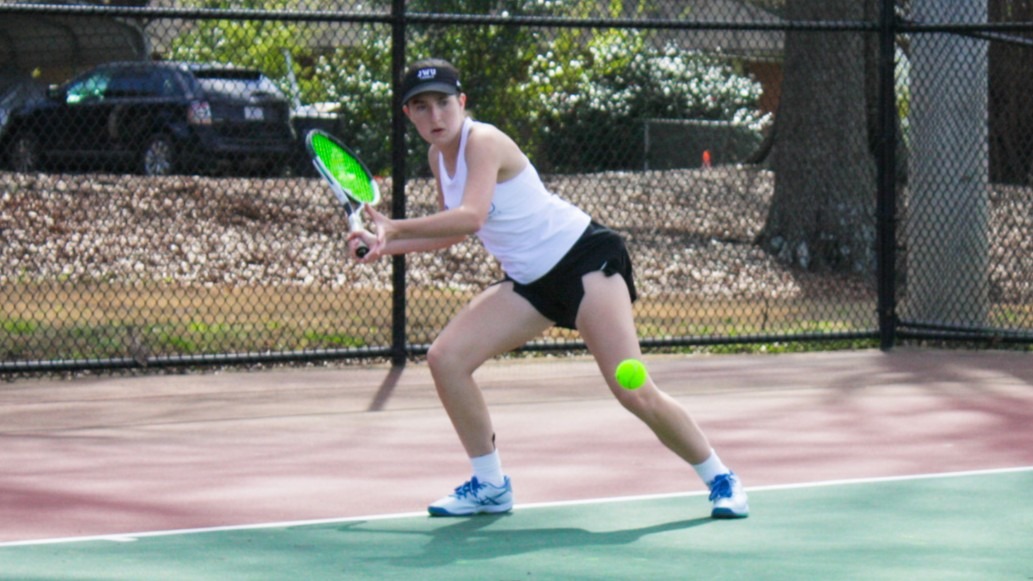 woman hitting a tennis ball